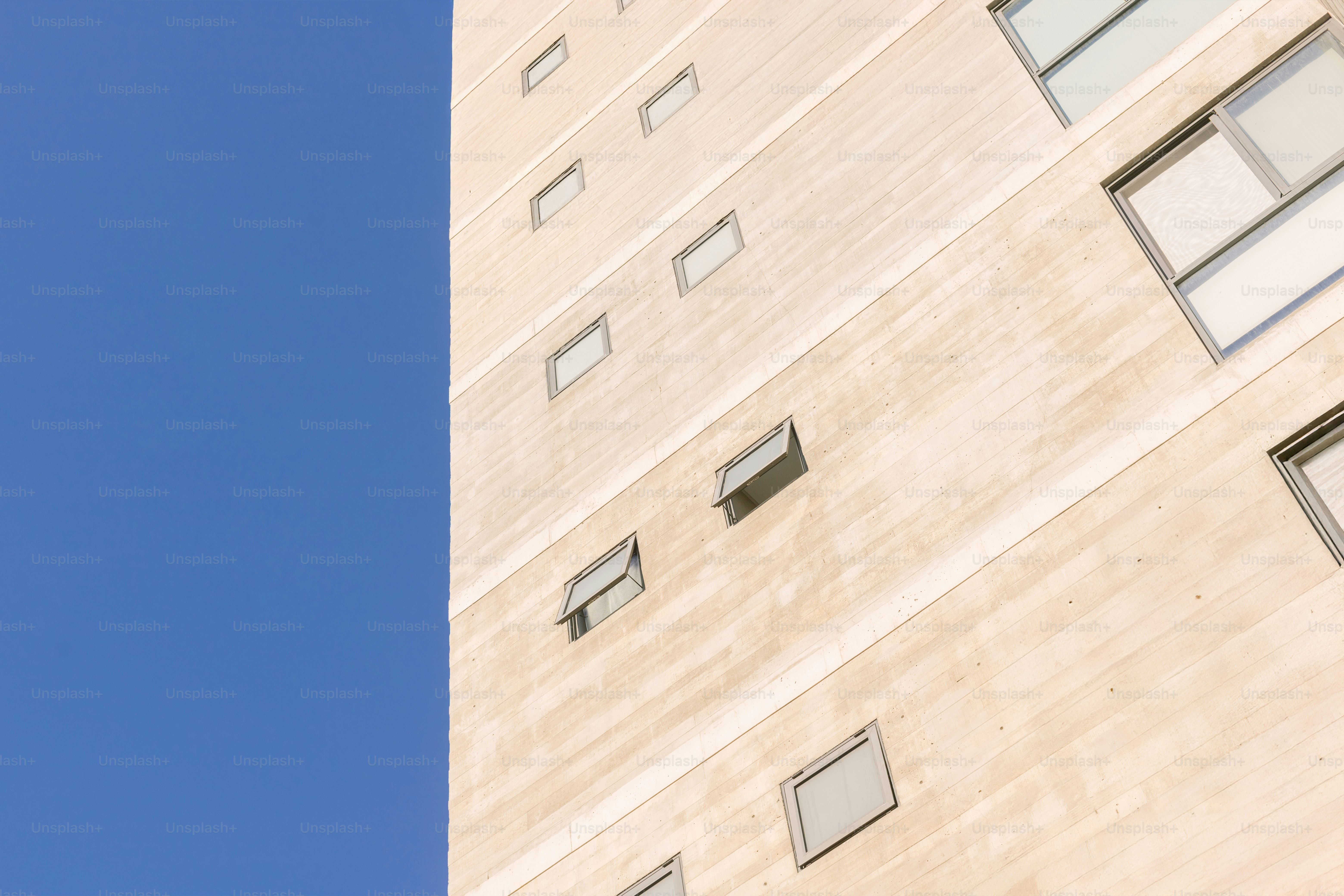 A tall building rises against a blue sky.