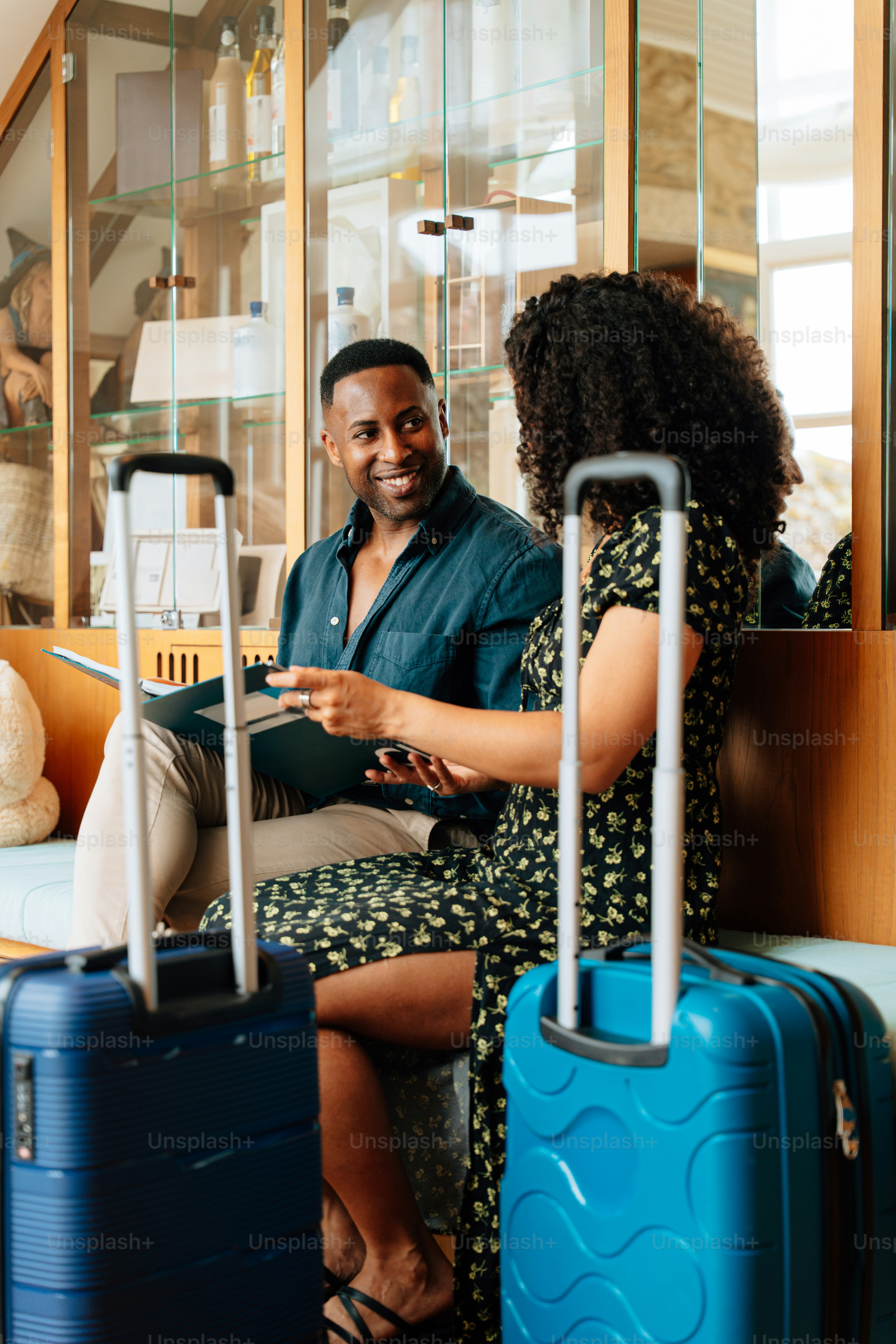 A couple discusses their travel plans with luggage.