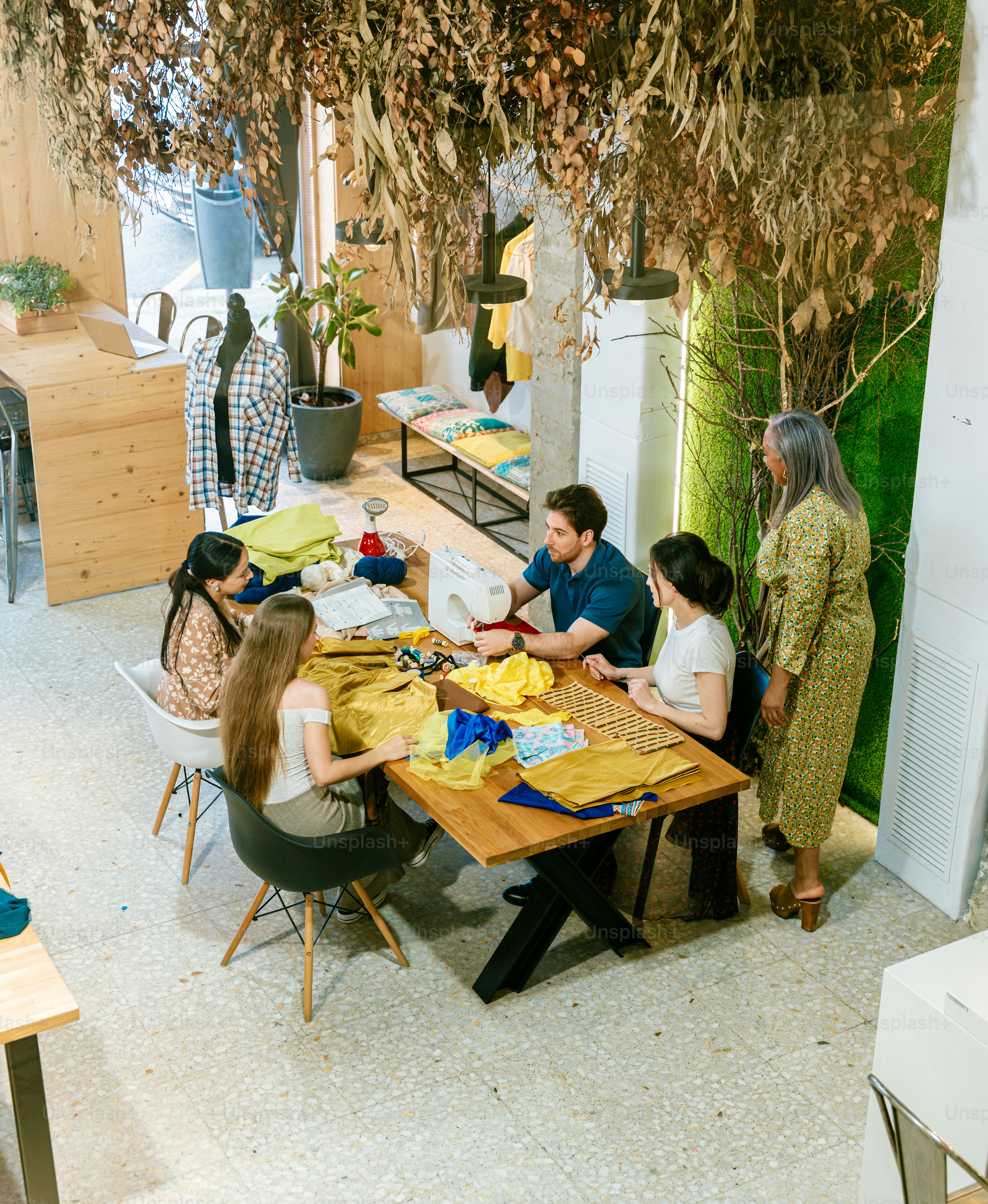 People gather around a table, possibly designing clothing.