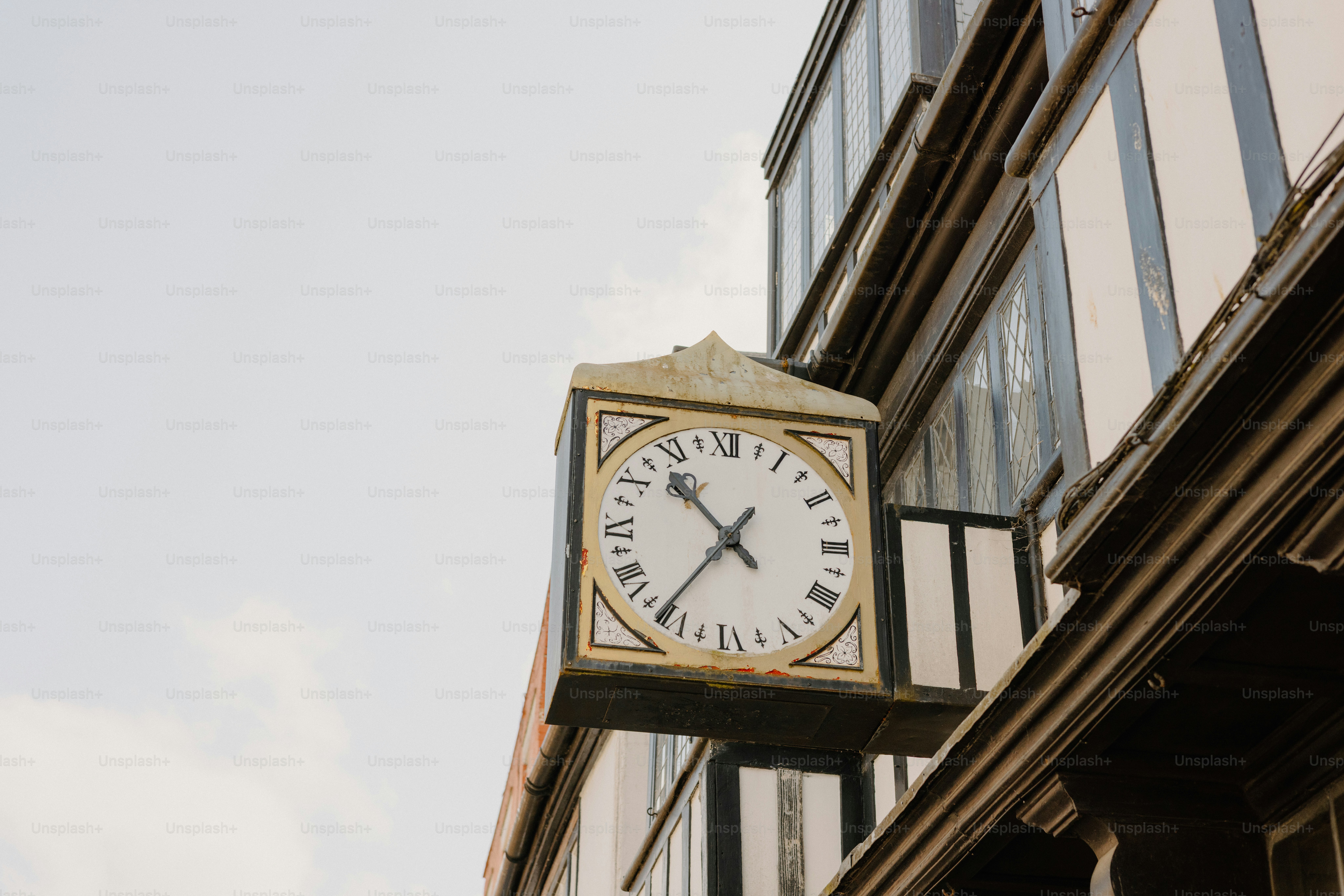A clock hangs on a historic building's exterior.