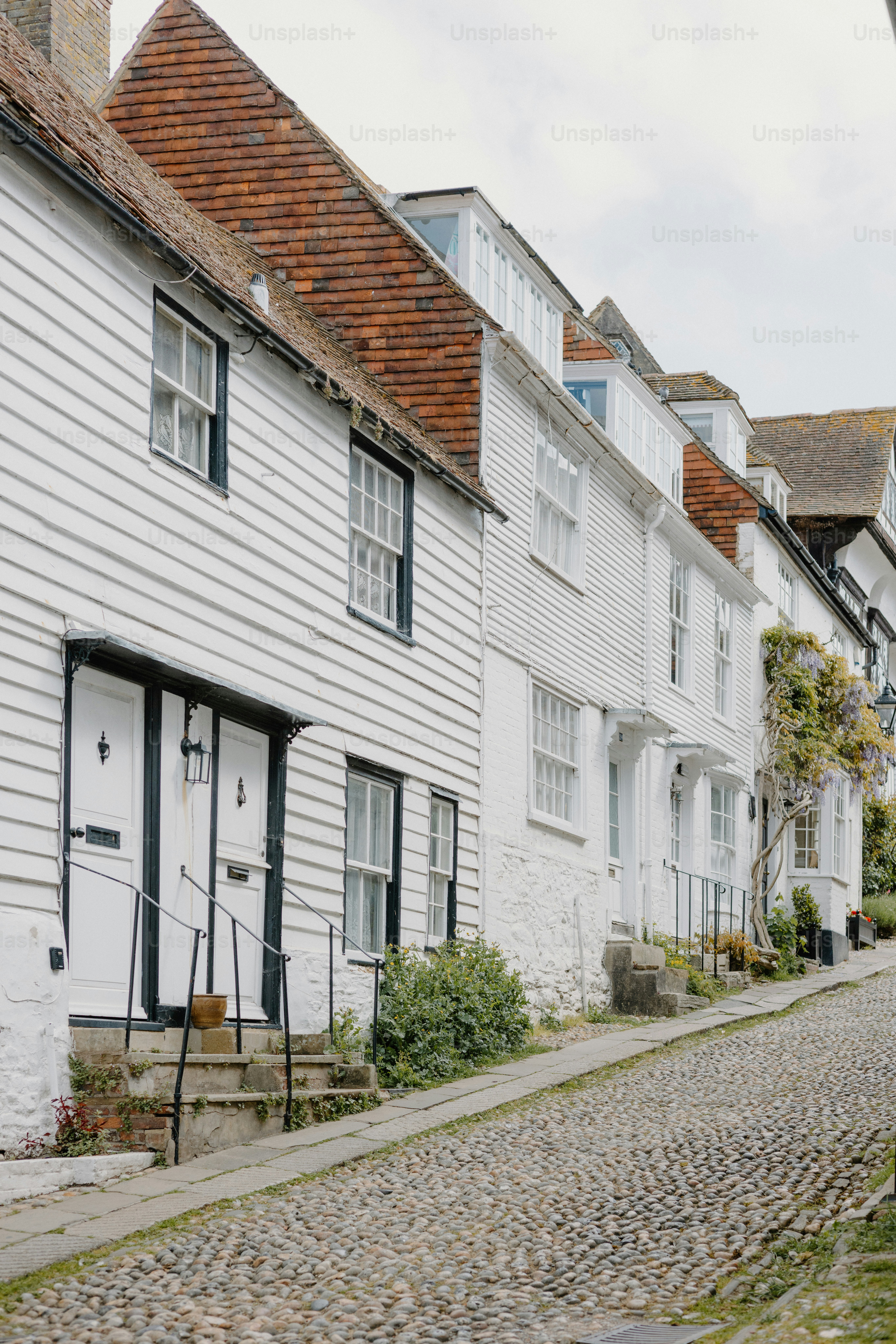 Weiße Häuser säumen eine Kopfsteinpflasterstraße.