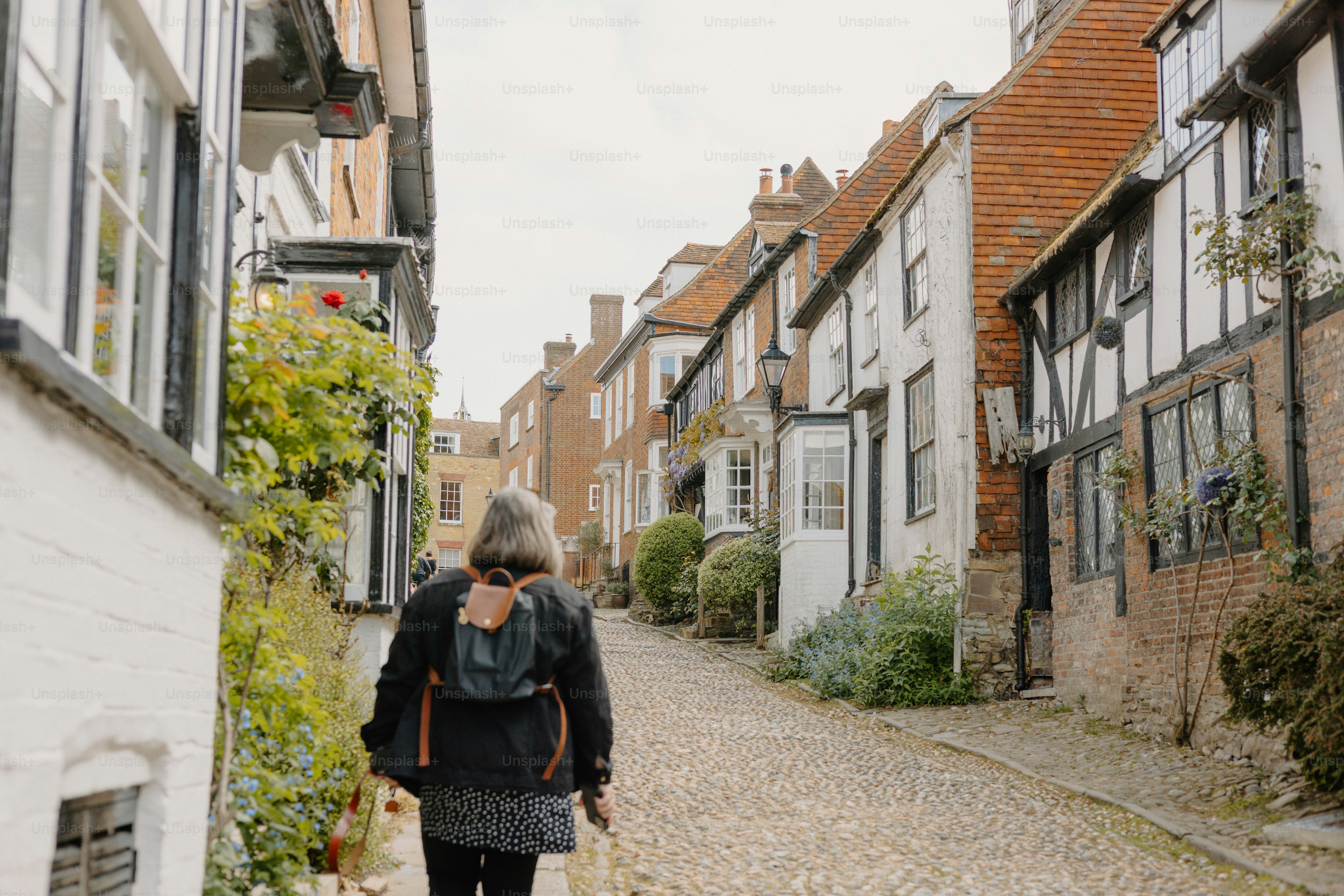 Frau geht eine charmante Kopfsteinpflasterstraße entlang.