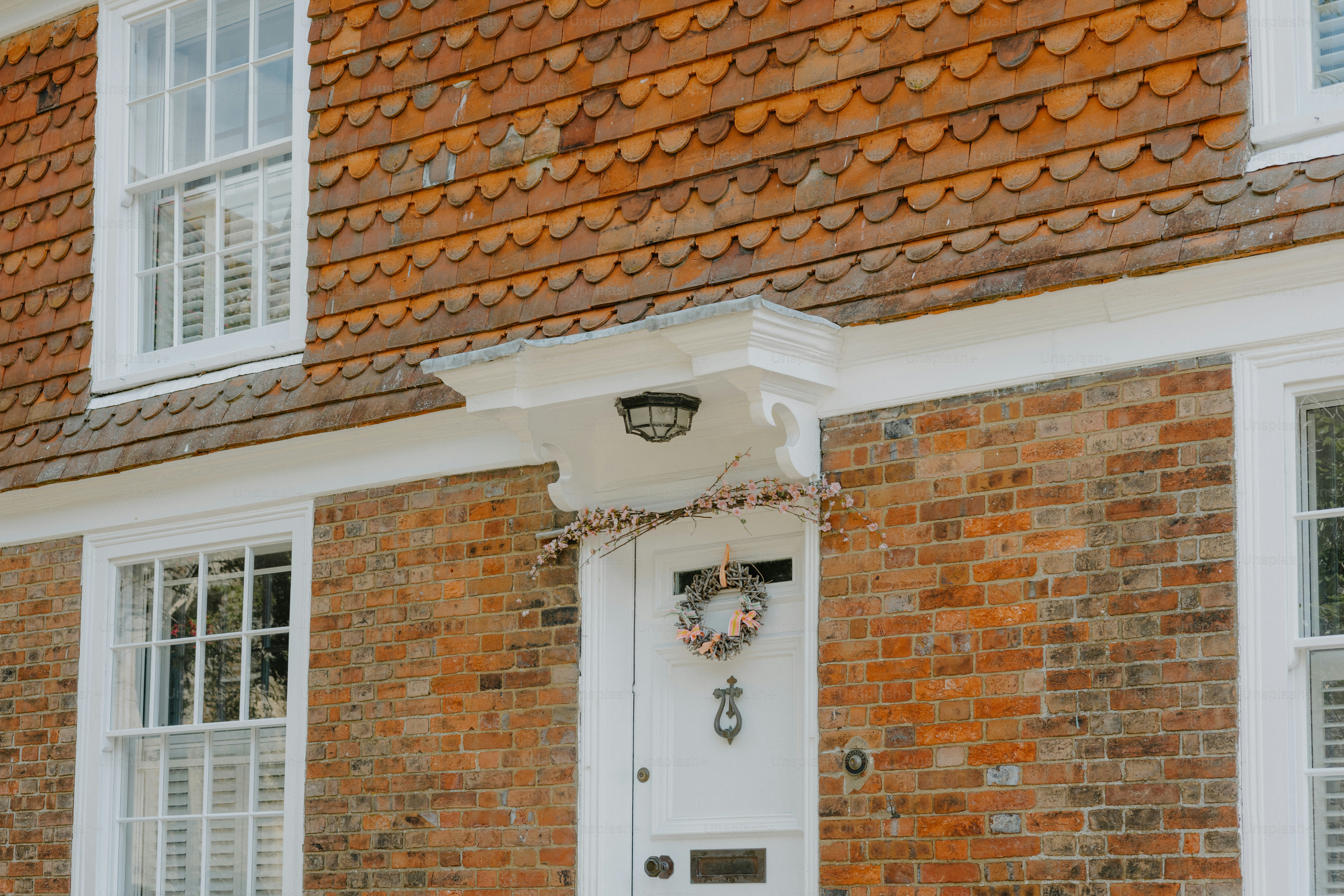 A brick house with white windows and door. photo – House Image on Unsplash