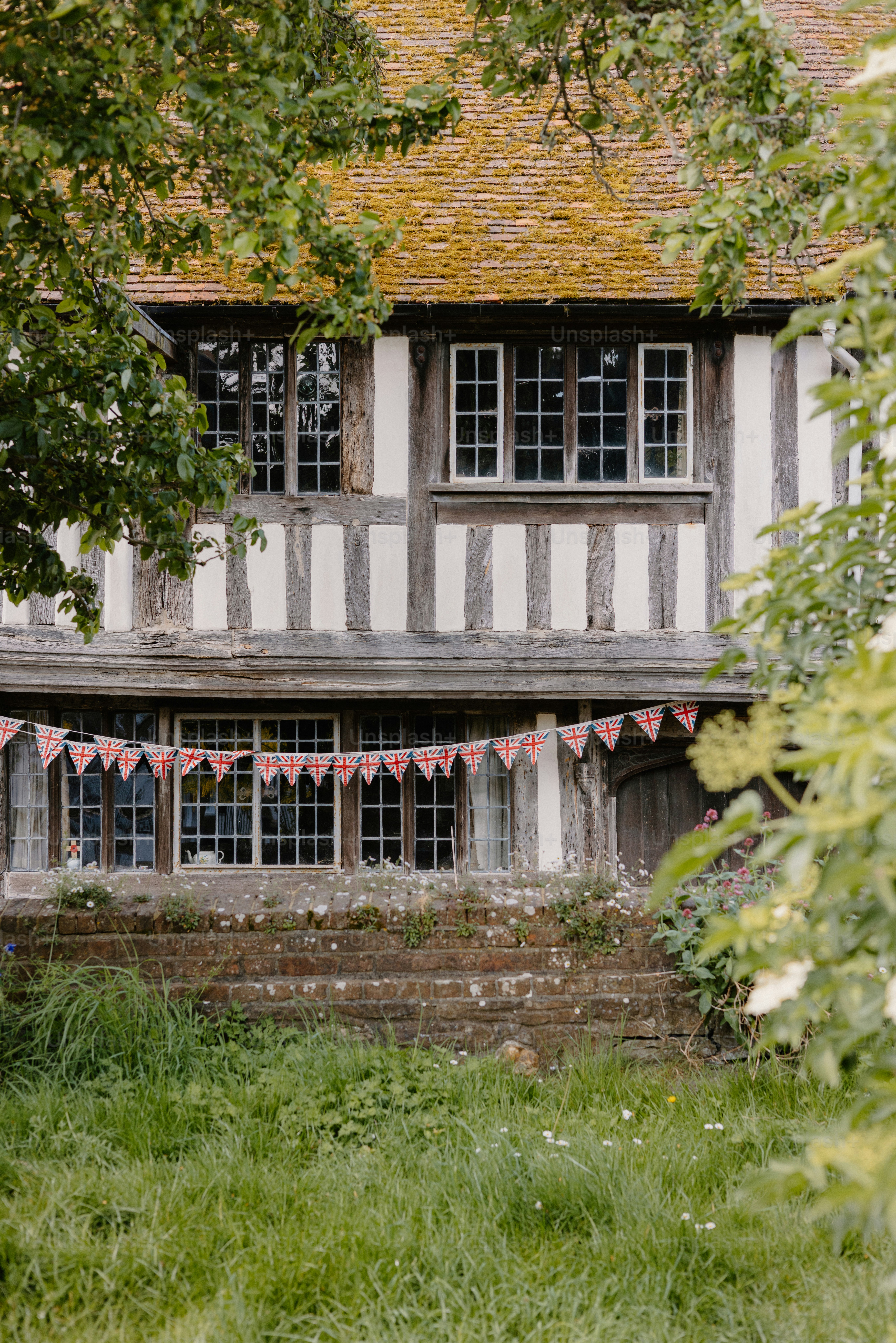 Schönes Ferienhaus, das mit Wimpeln und überwuchertem Gras geschmückt ist.