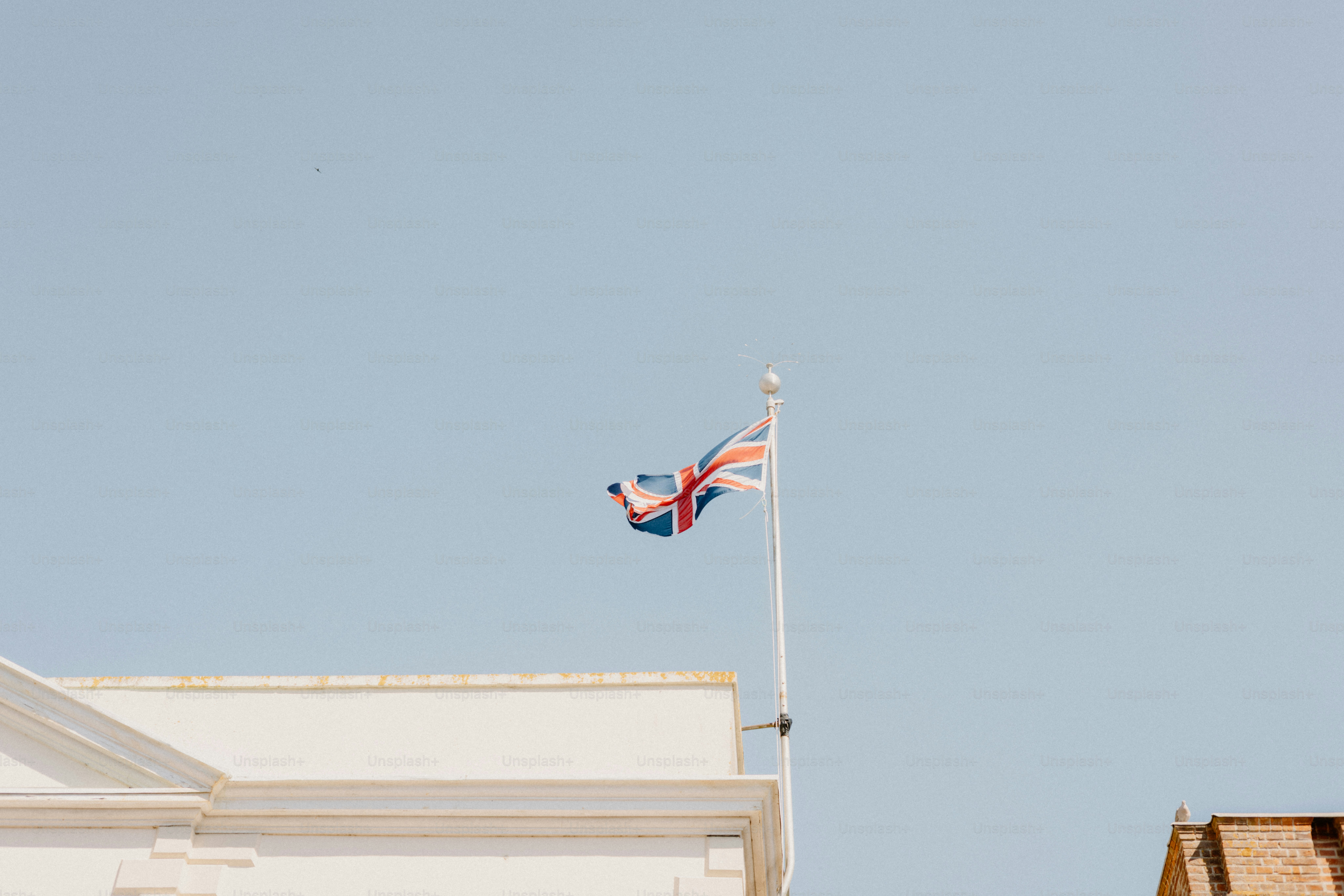 Eine Union Jack-Flagge weht am blauen Himmel.