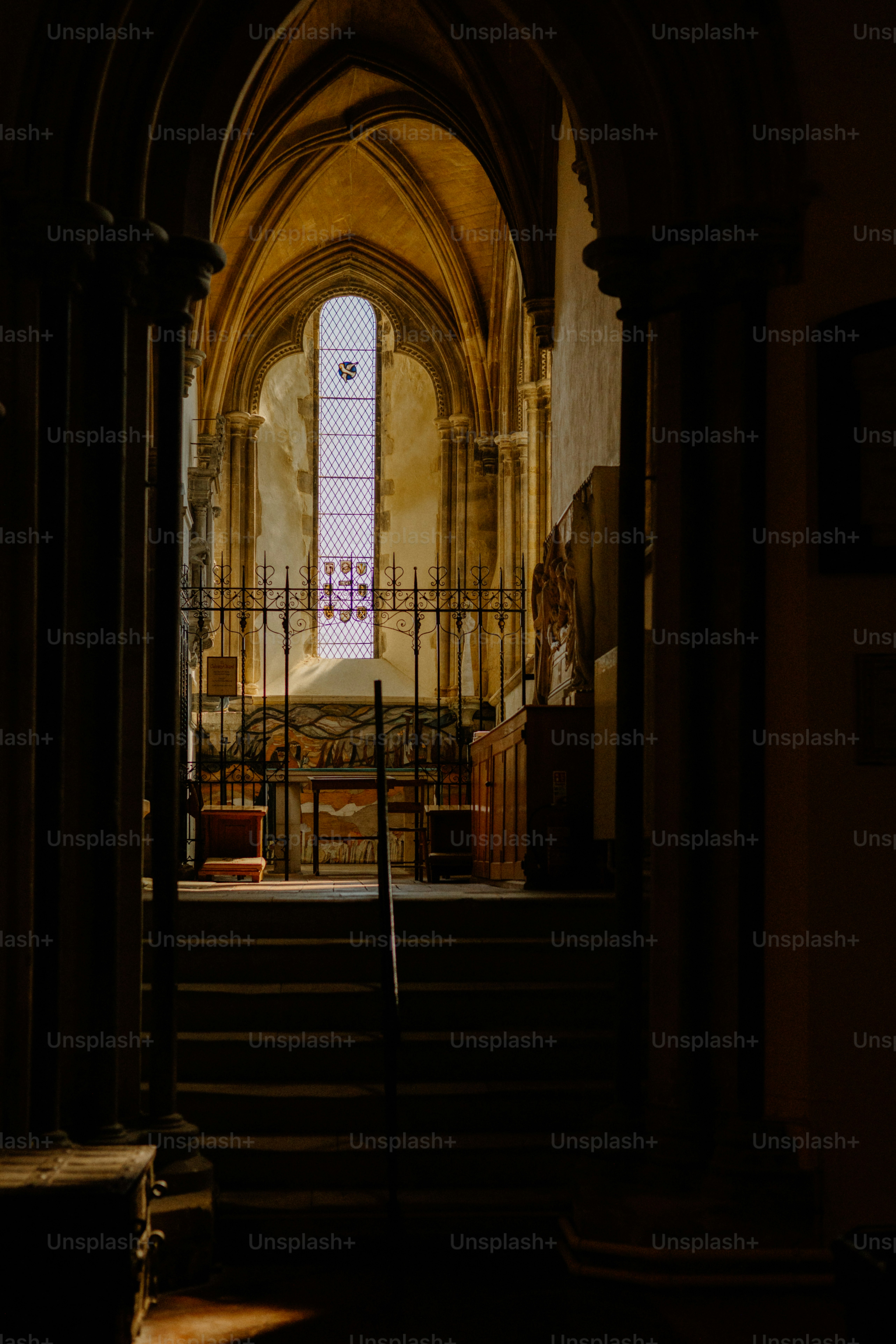 Un interior arqueado conduce a una vidriera luminosa.