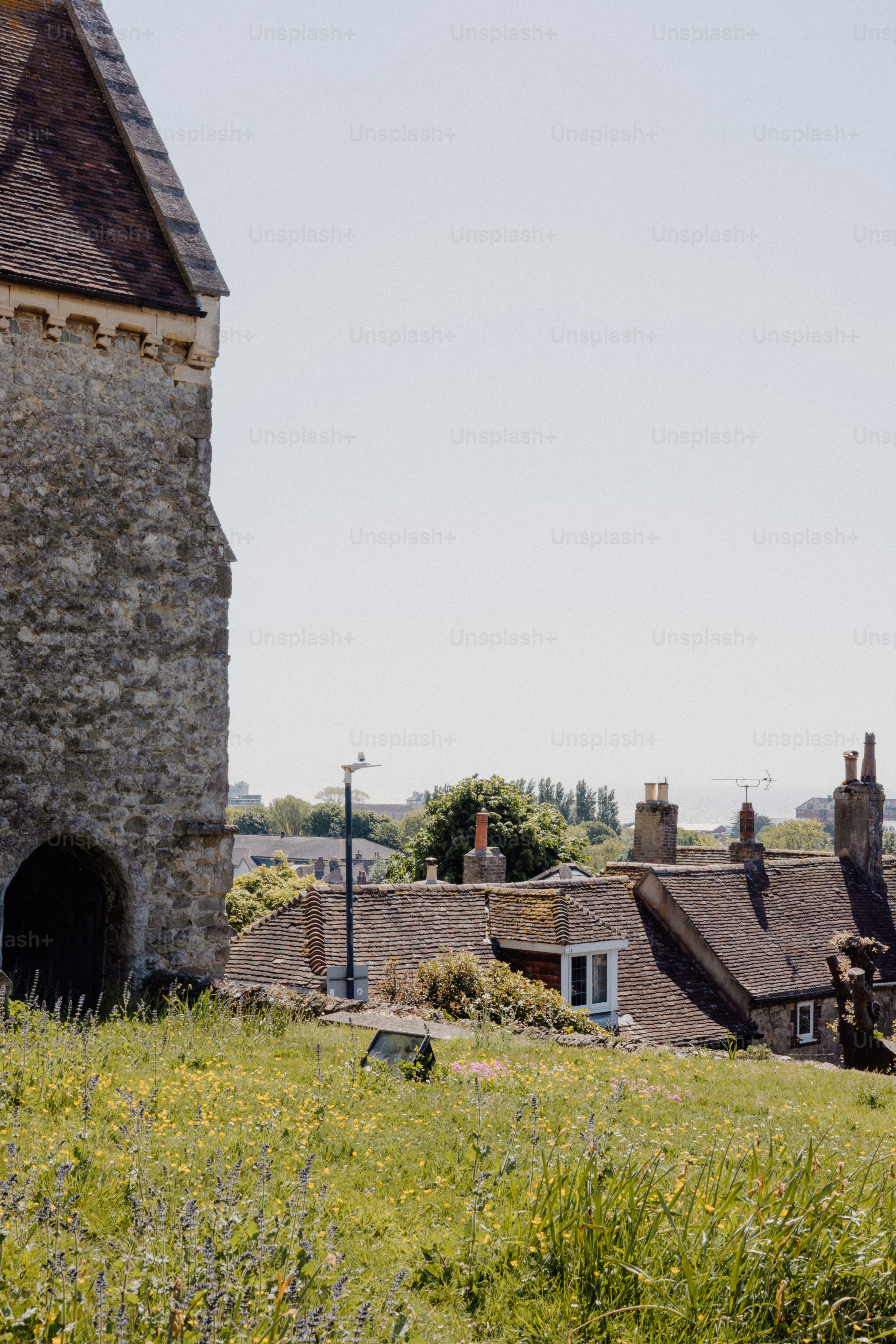 Stone tower overlooks a grassy hillside and rooftops.