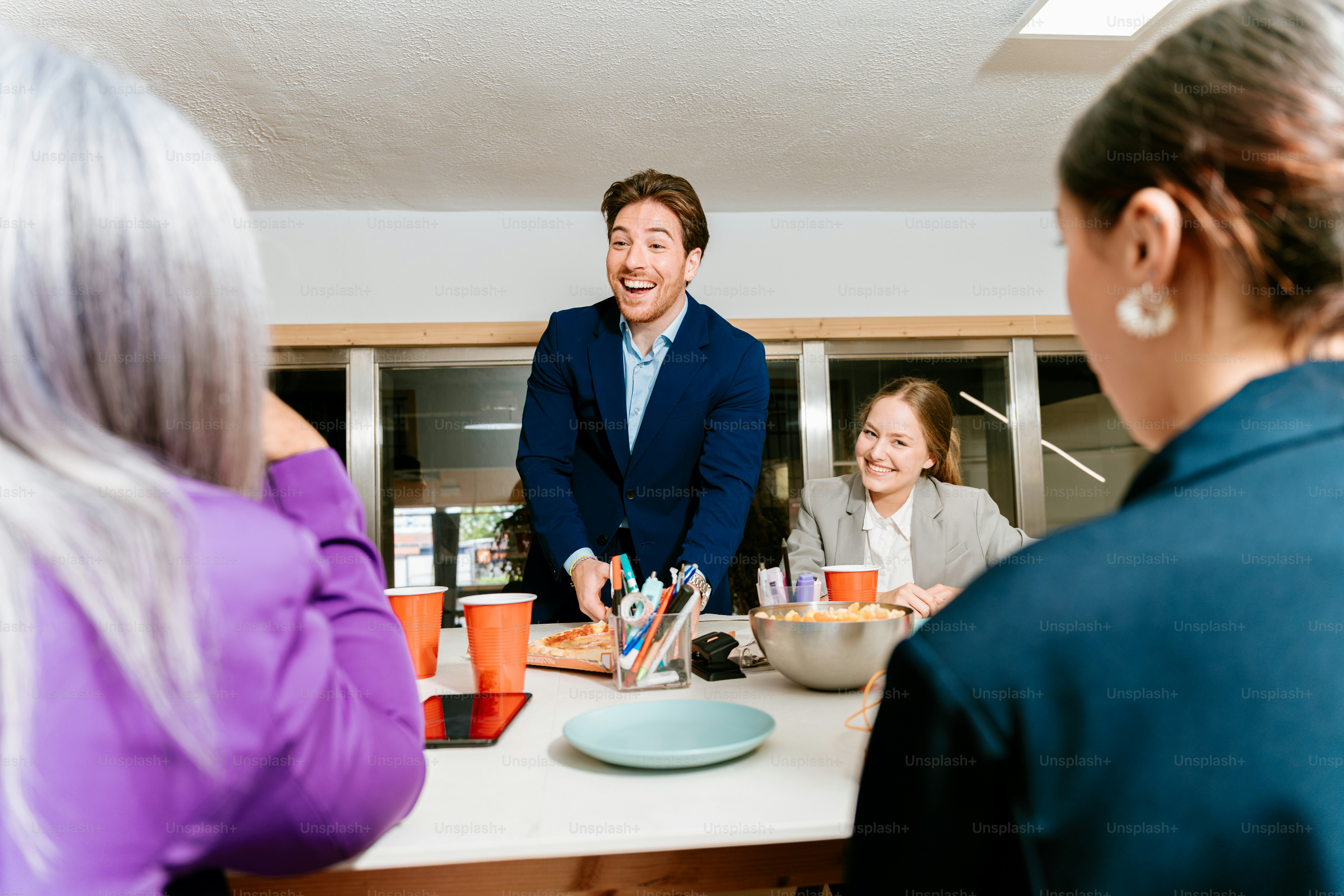 Colleagues are enjoying pizza and chatting together.