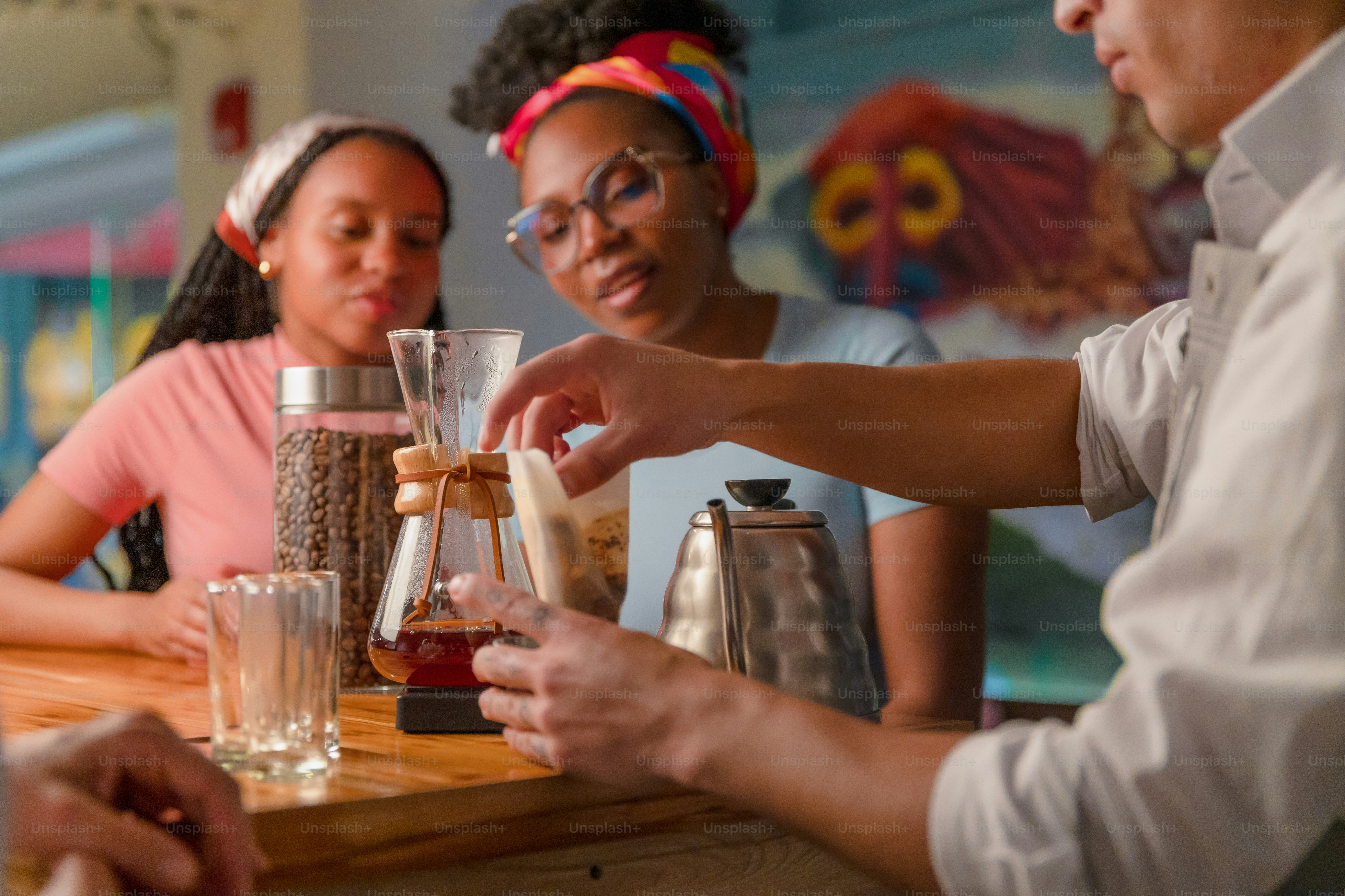 Barista prepares coffee for customers at a cafe.