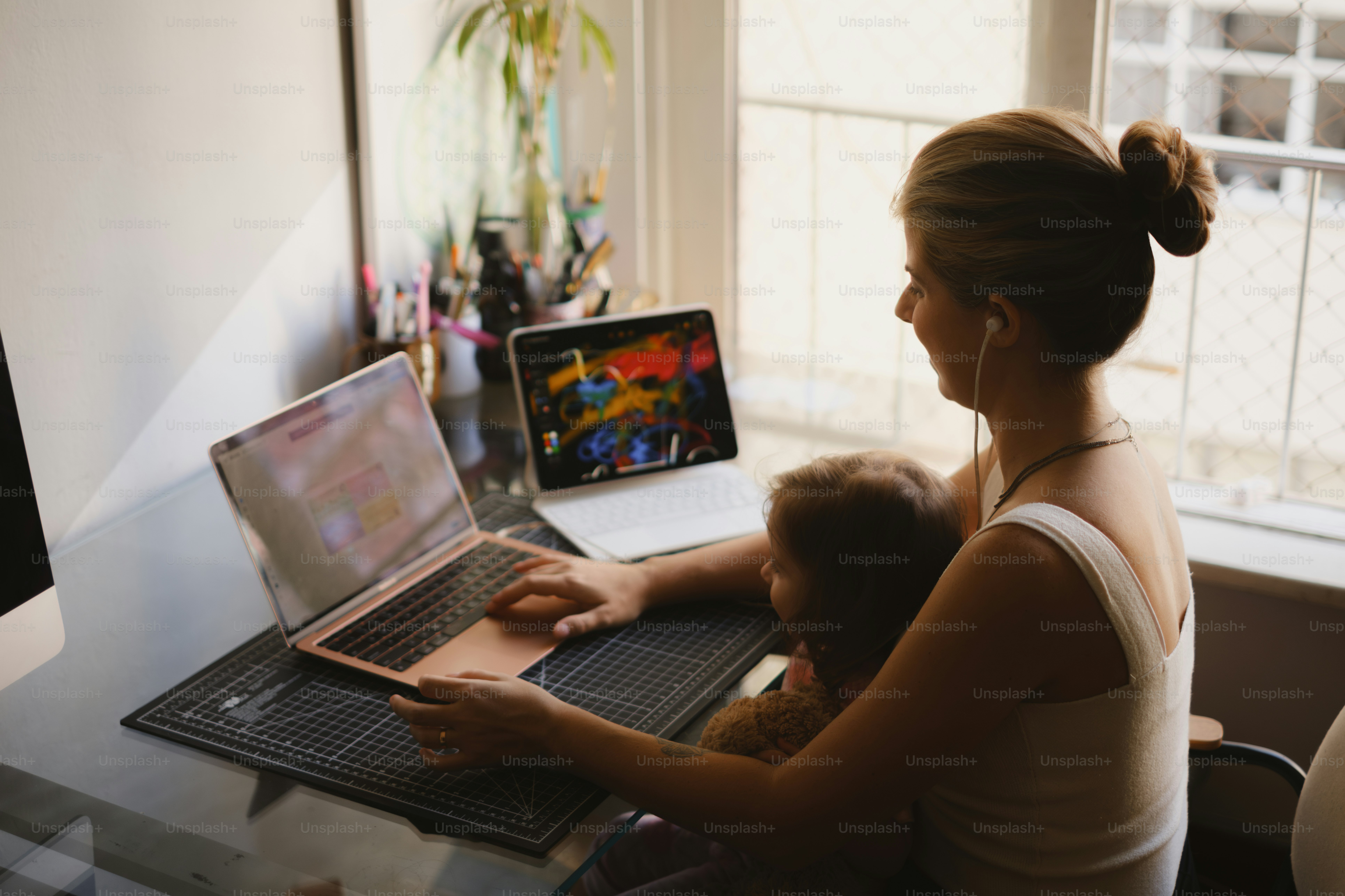 Woman works from home with a child.