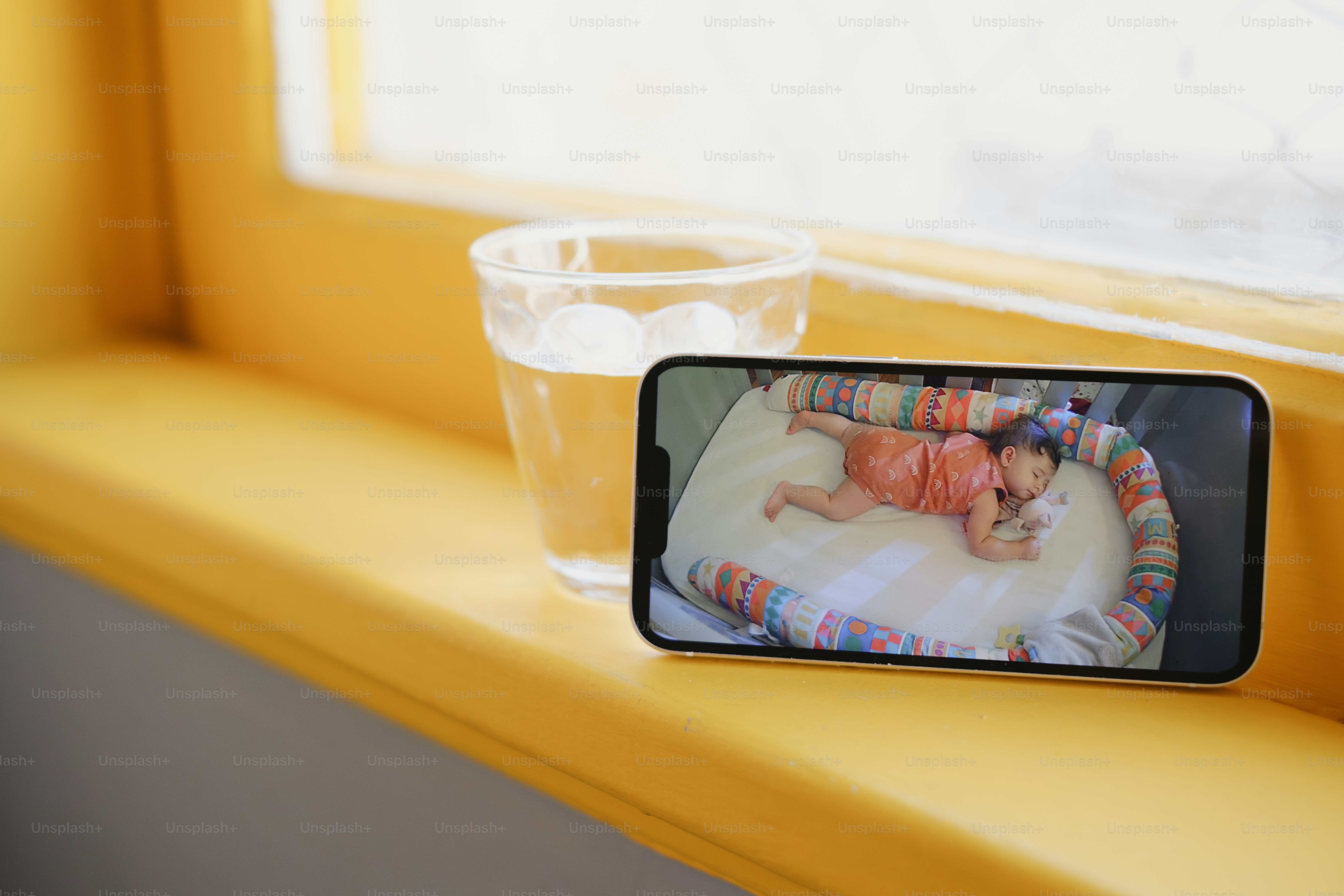 A baby sleeps on a phone screen.