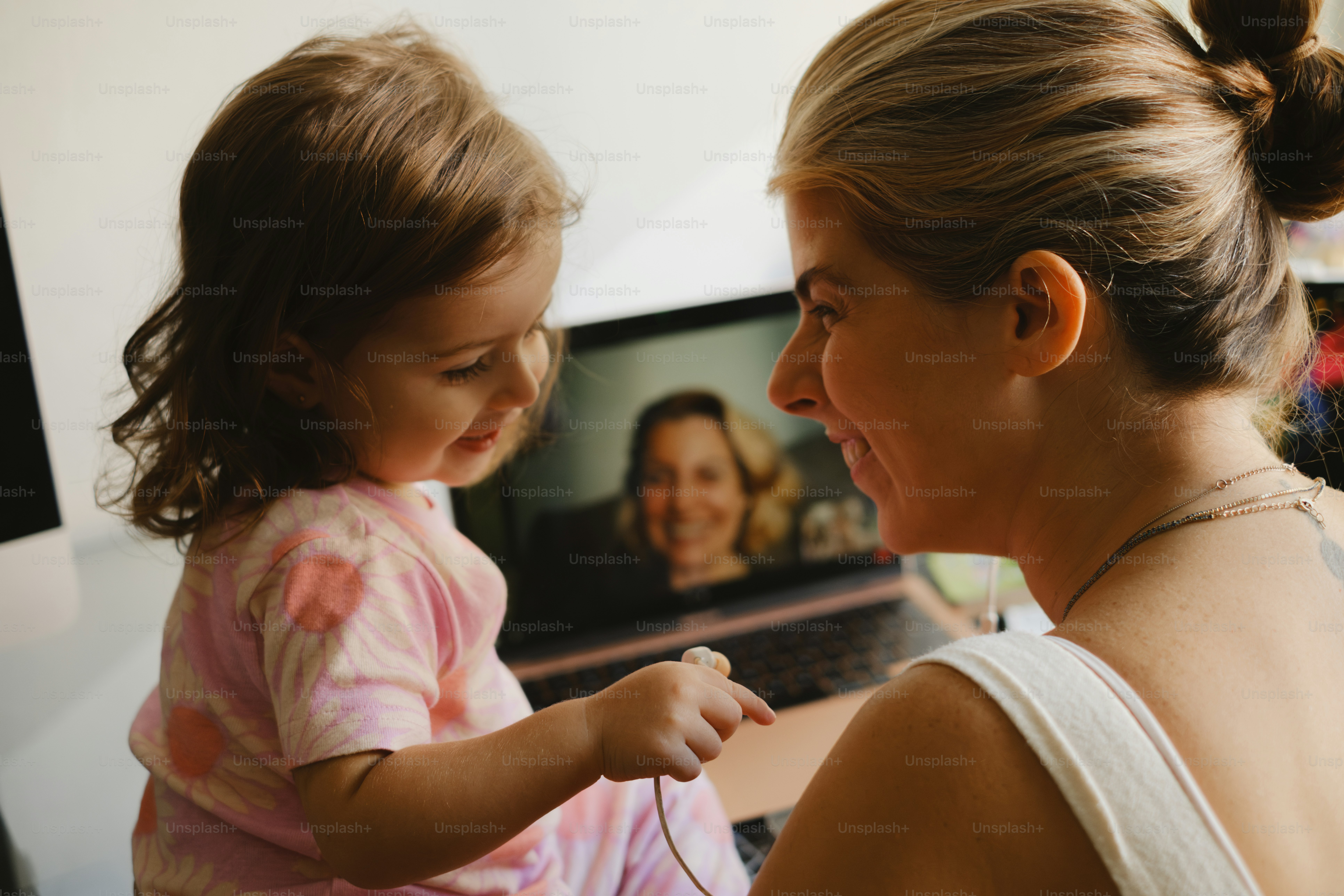 A mother and daughter video chat with someone.