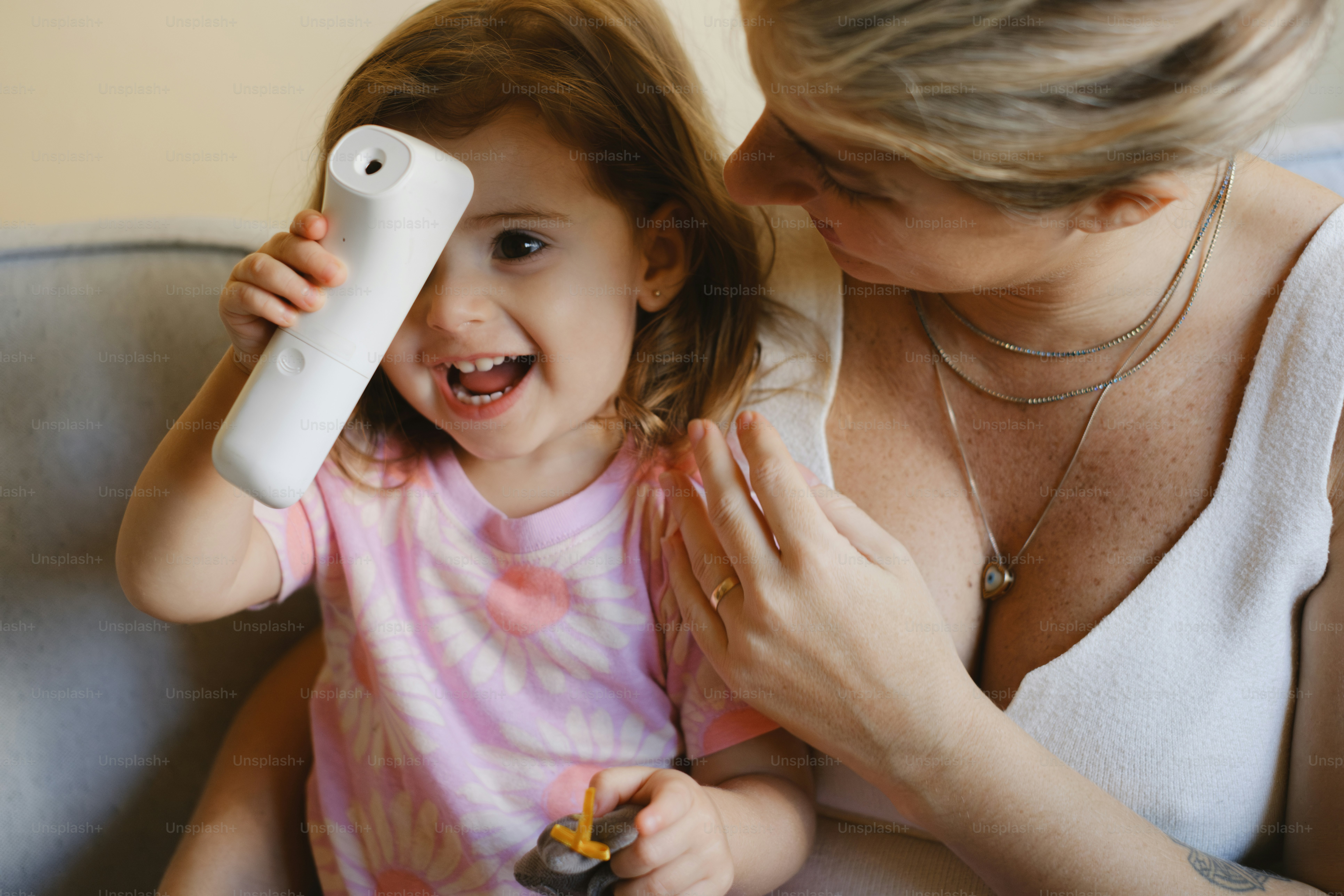 A smiling child plays with a medical device.