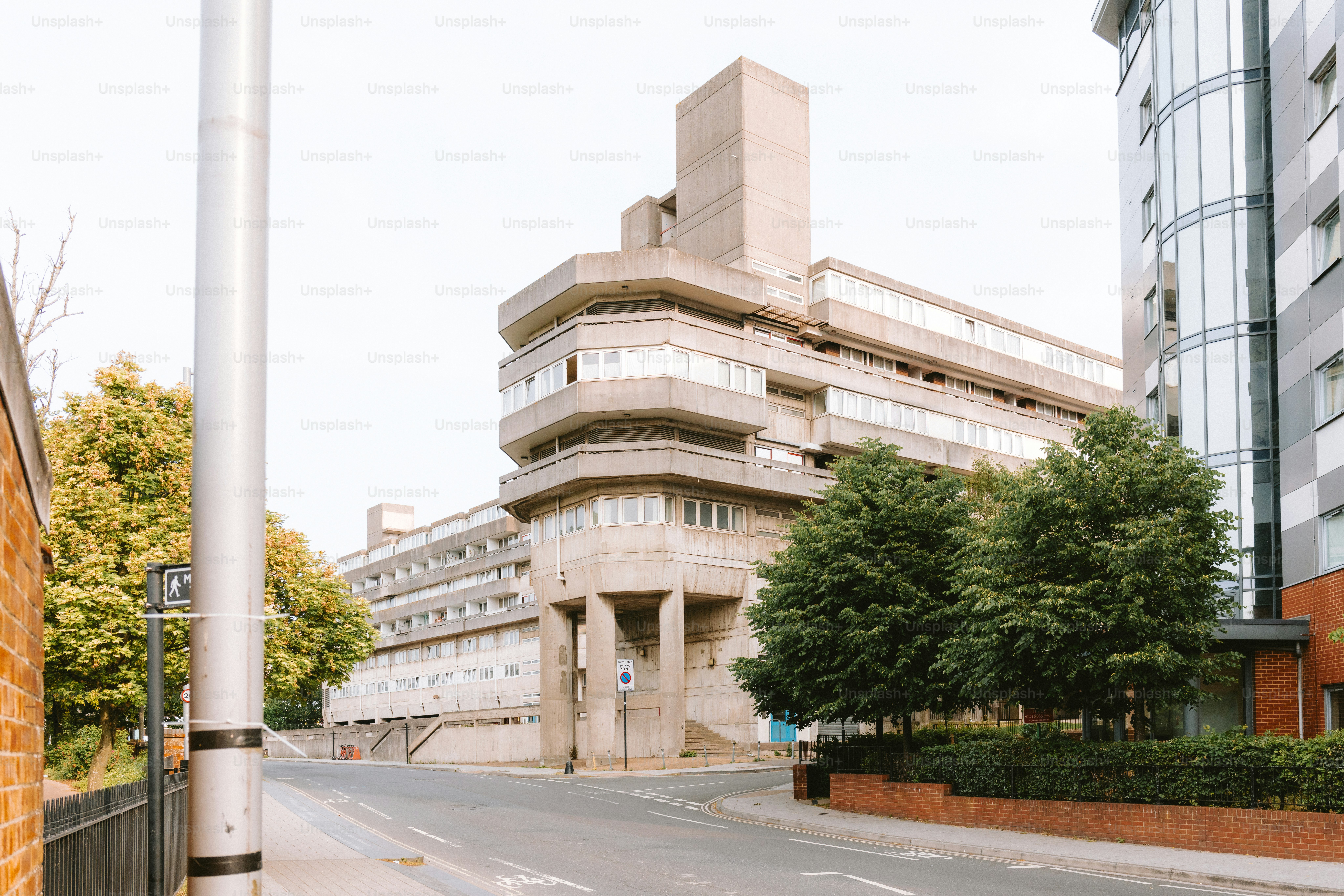 Un edificio brutalista de hormigón se encuentra junto a una calle.