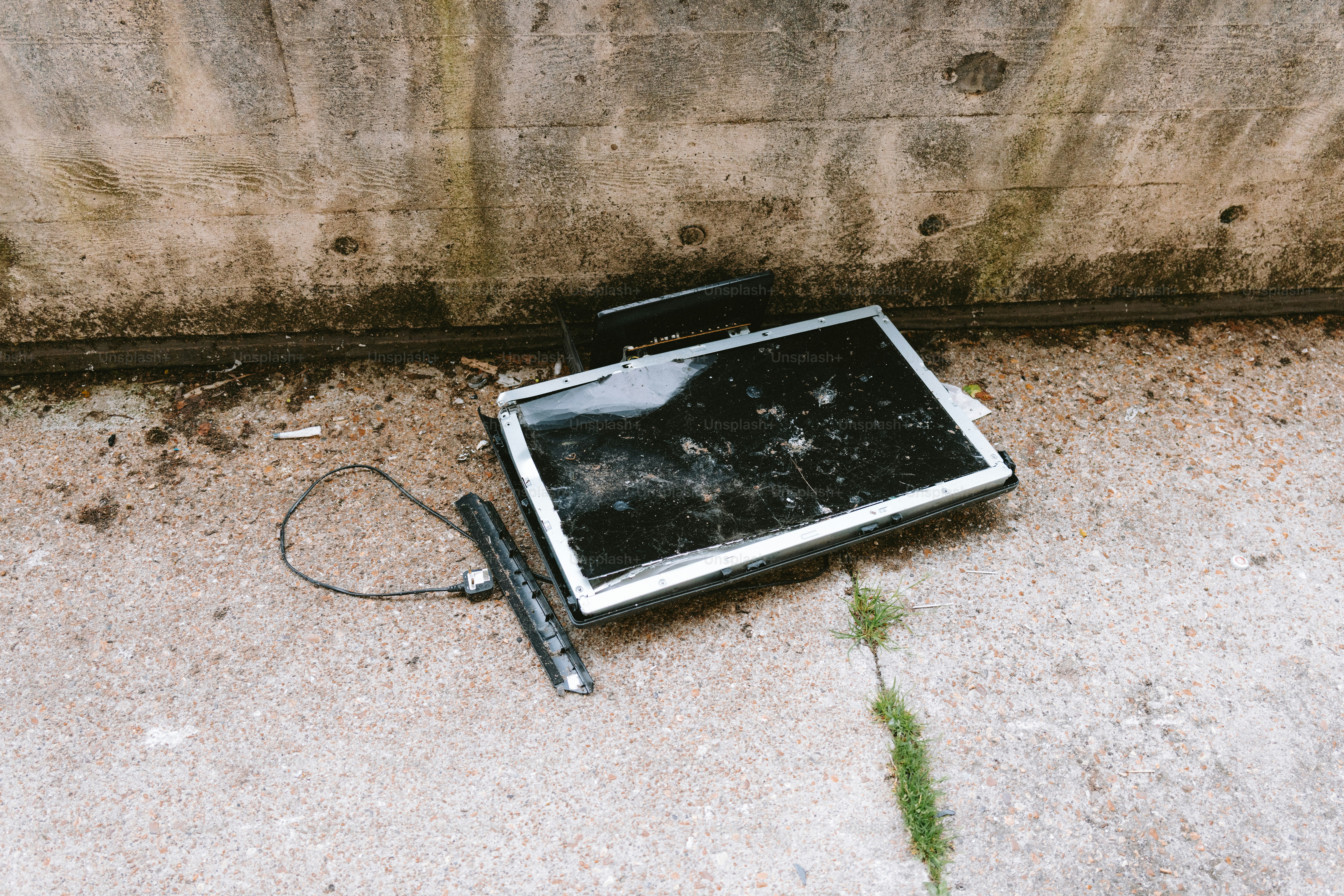 A broken TV screen lies abandoned on the ground.
