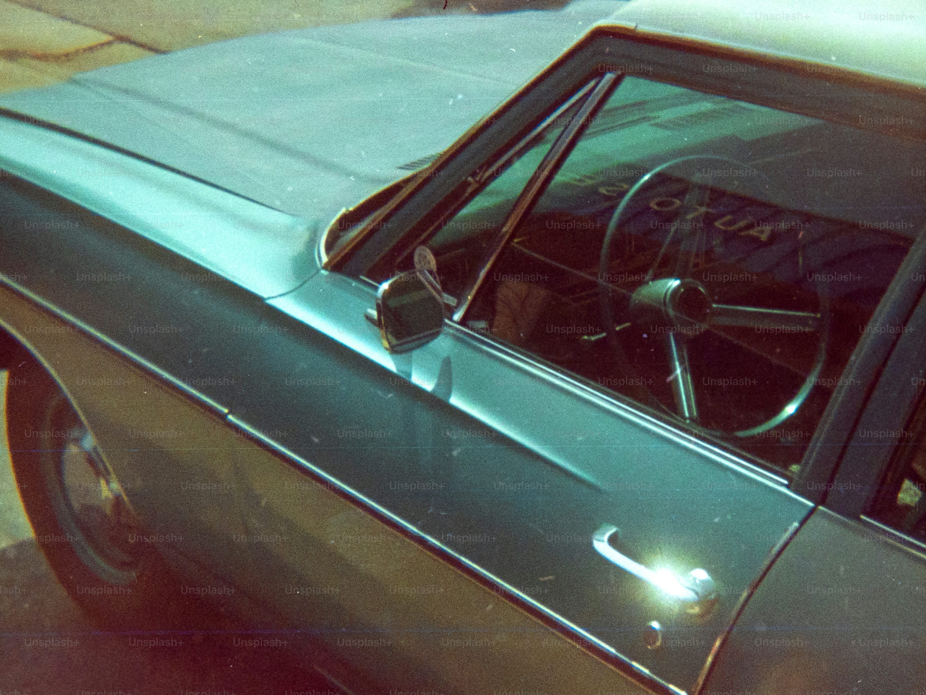 Here's a caption: a green vintage car's side.