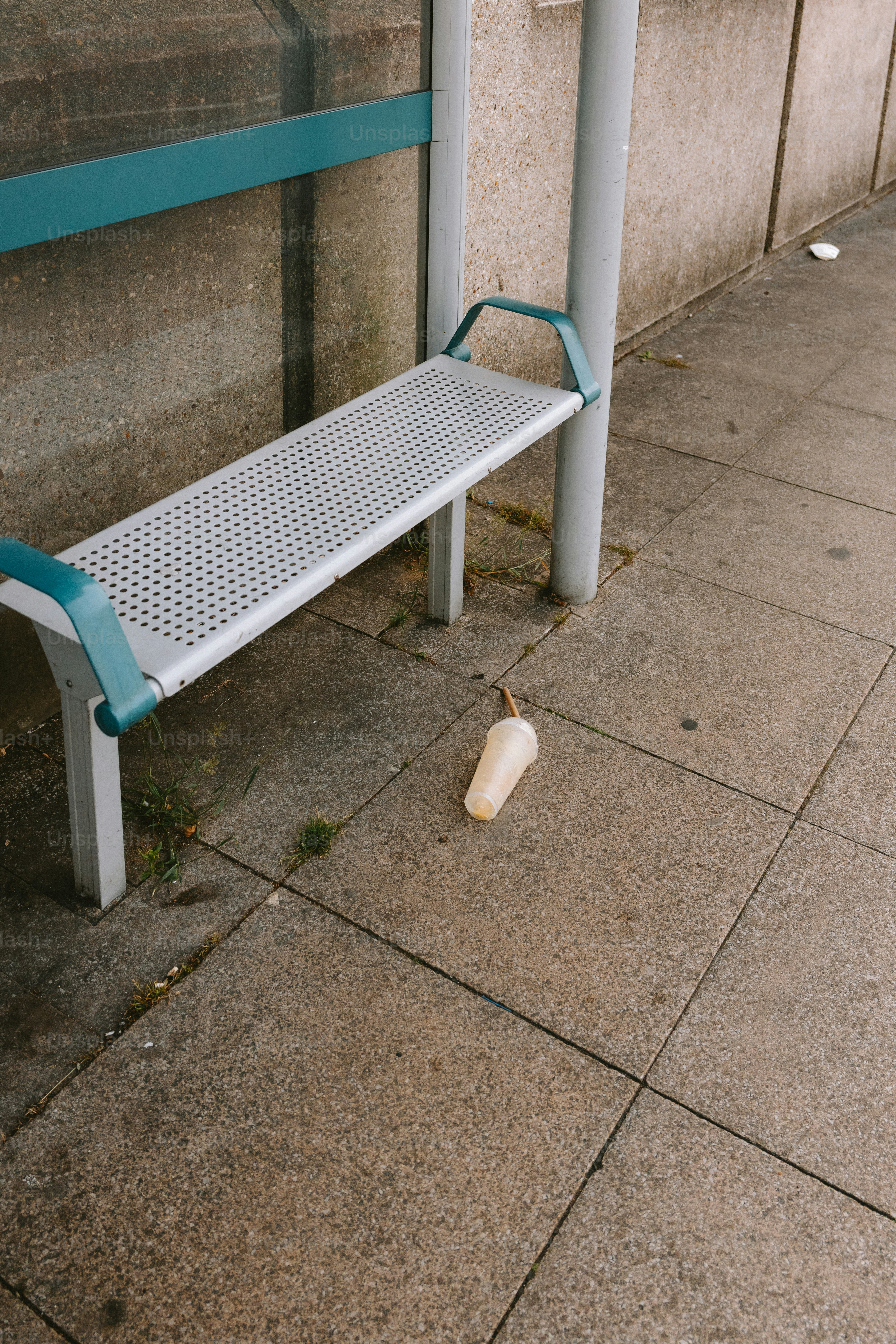 A discarded drink cup rests near a bus stop.