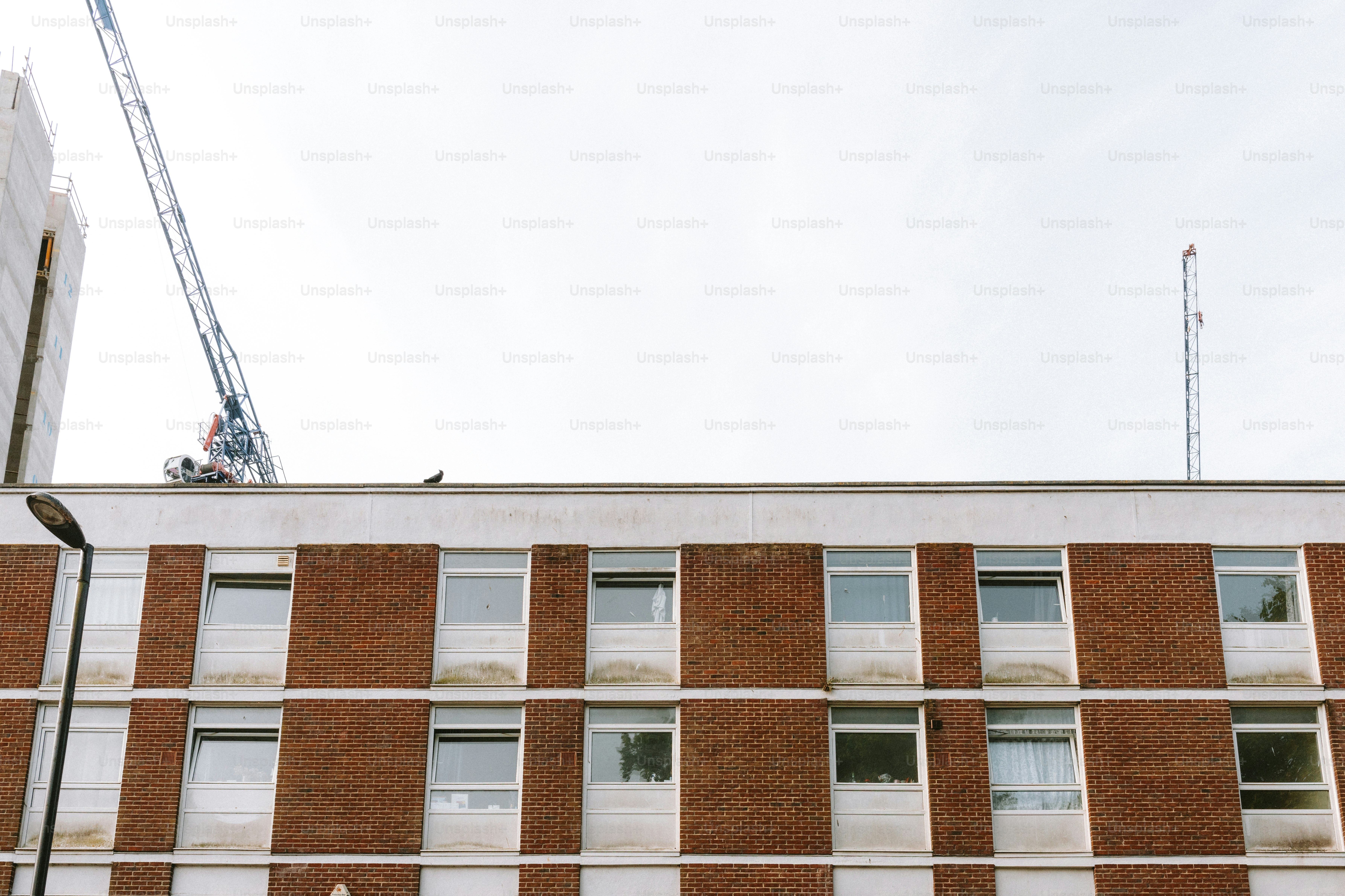 Brick building with windows, under cloudy sky.