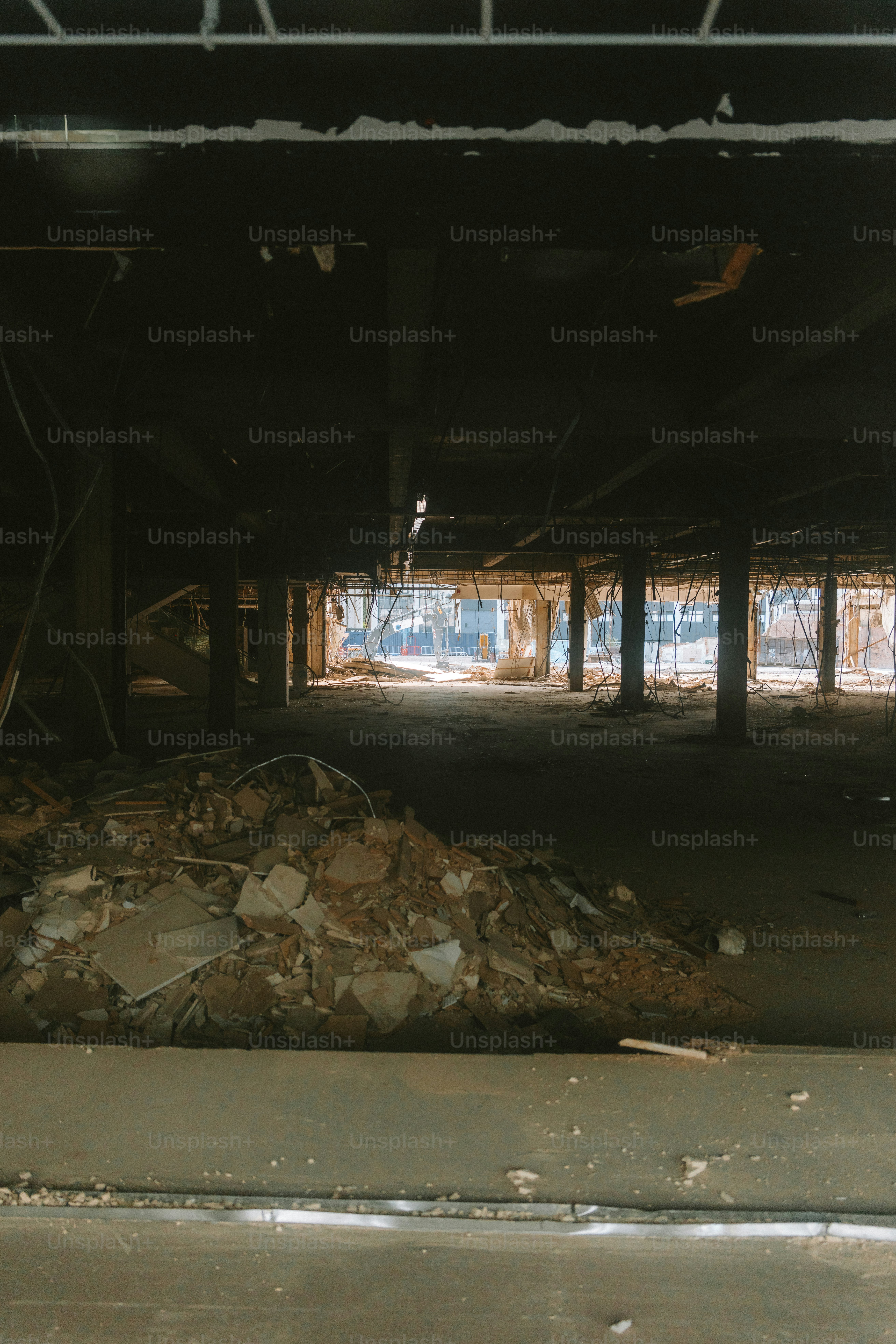 Inside a demolished building, debris lit by daylight.
