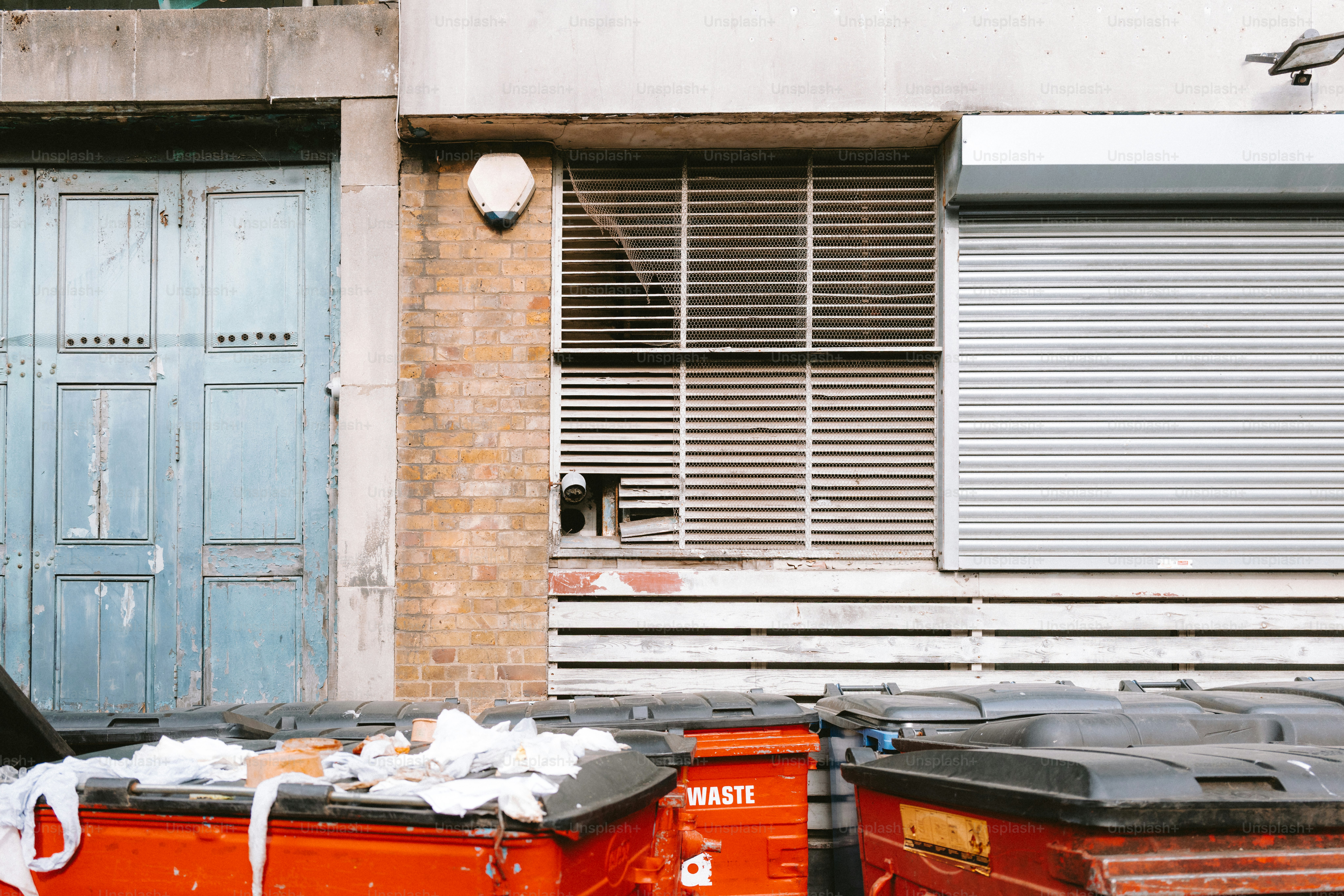 An urban scene shows buildings and overflowing dumpsters.