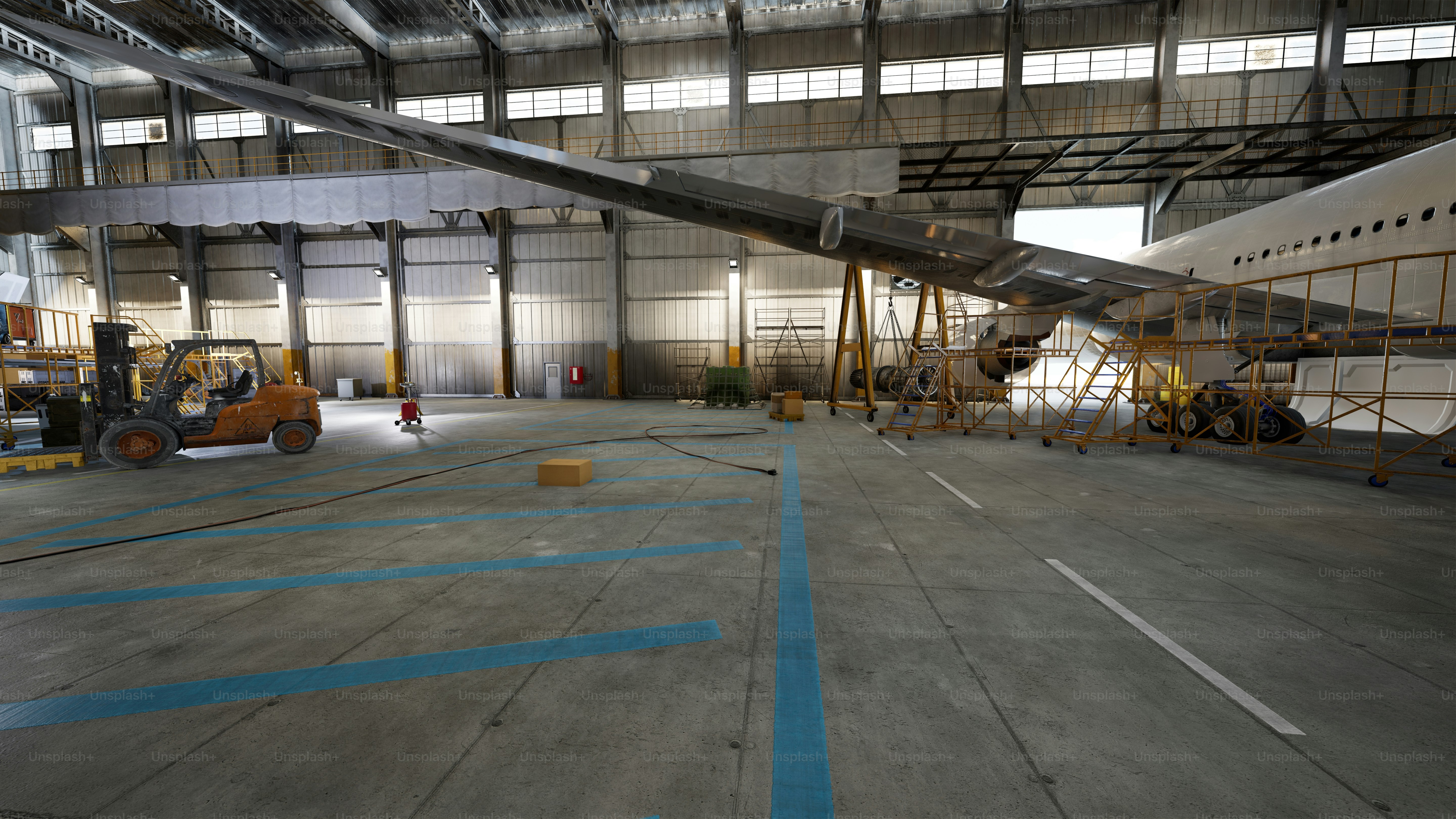 Airplane wing being worked on inside a hangar.