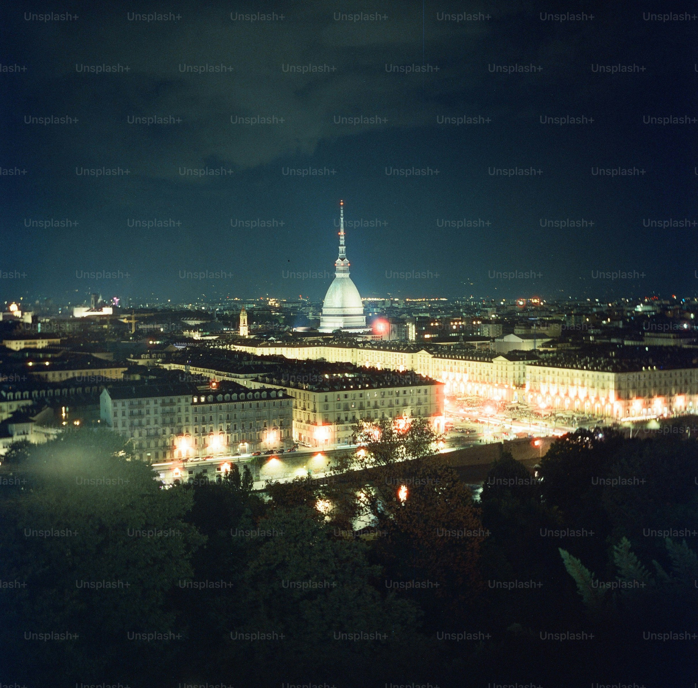 Cityscape at night with a prominent tower.