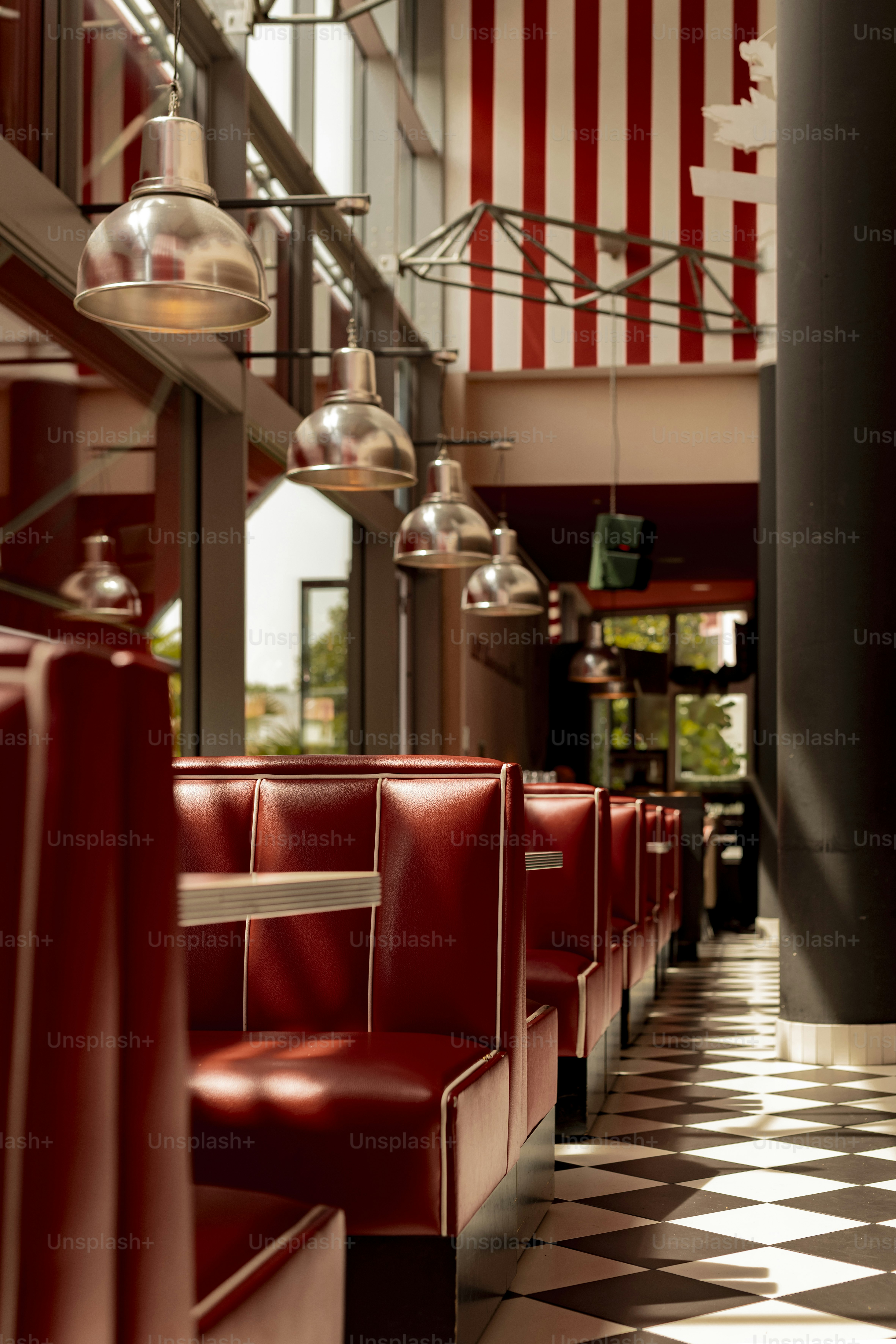 A retro diner features red booths and checkered floors.