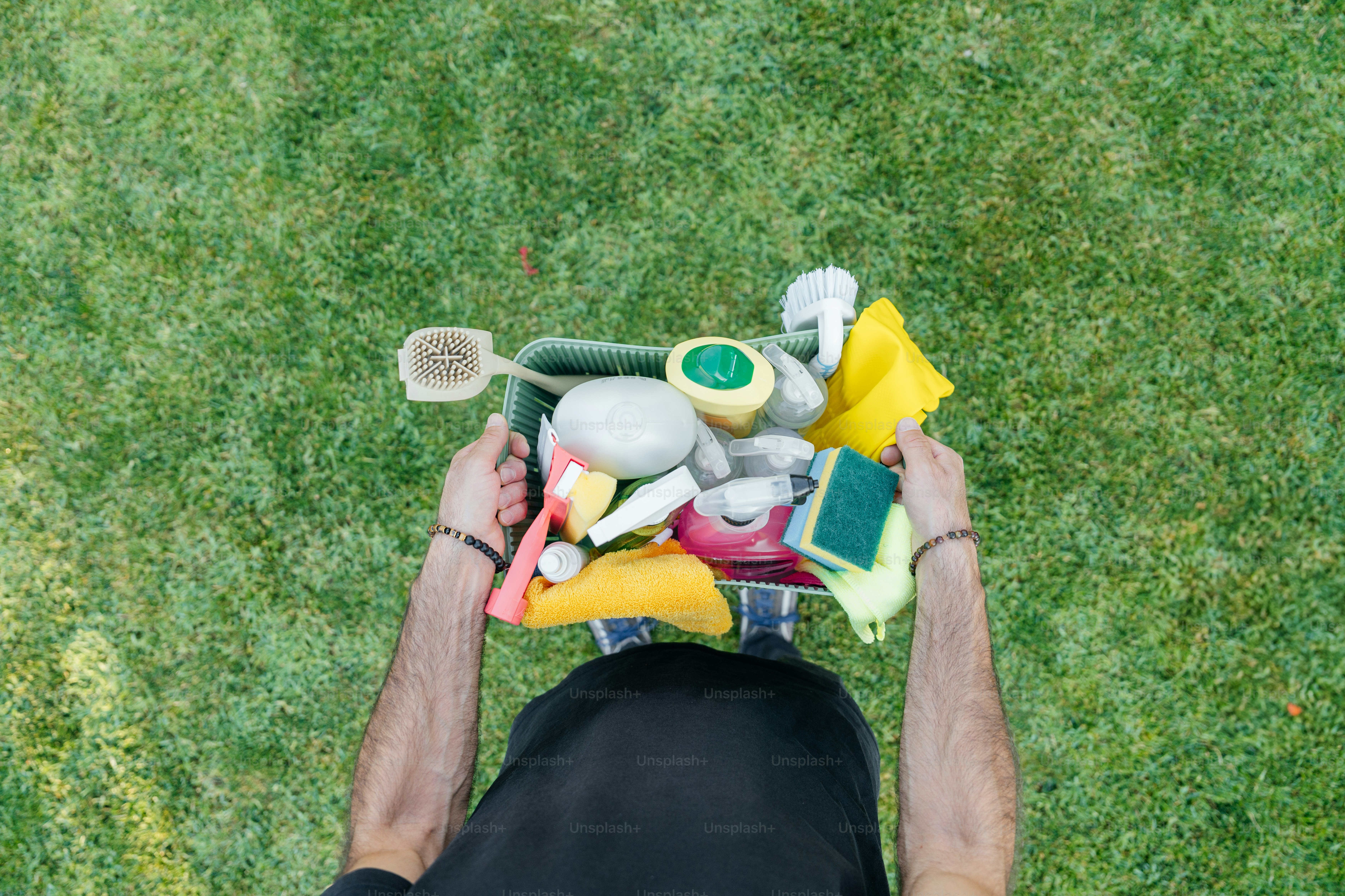 Hombre sosteniendo un carrito de artículos de limpieza.