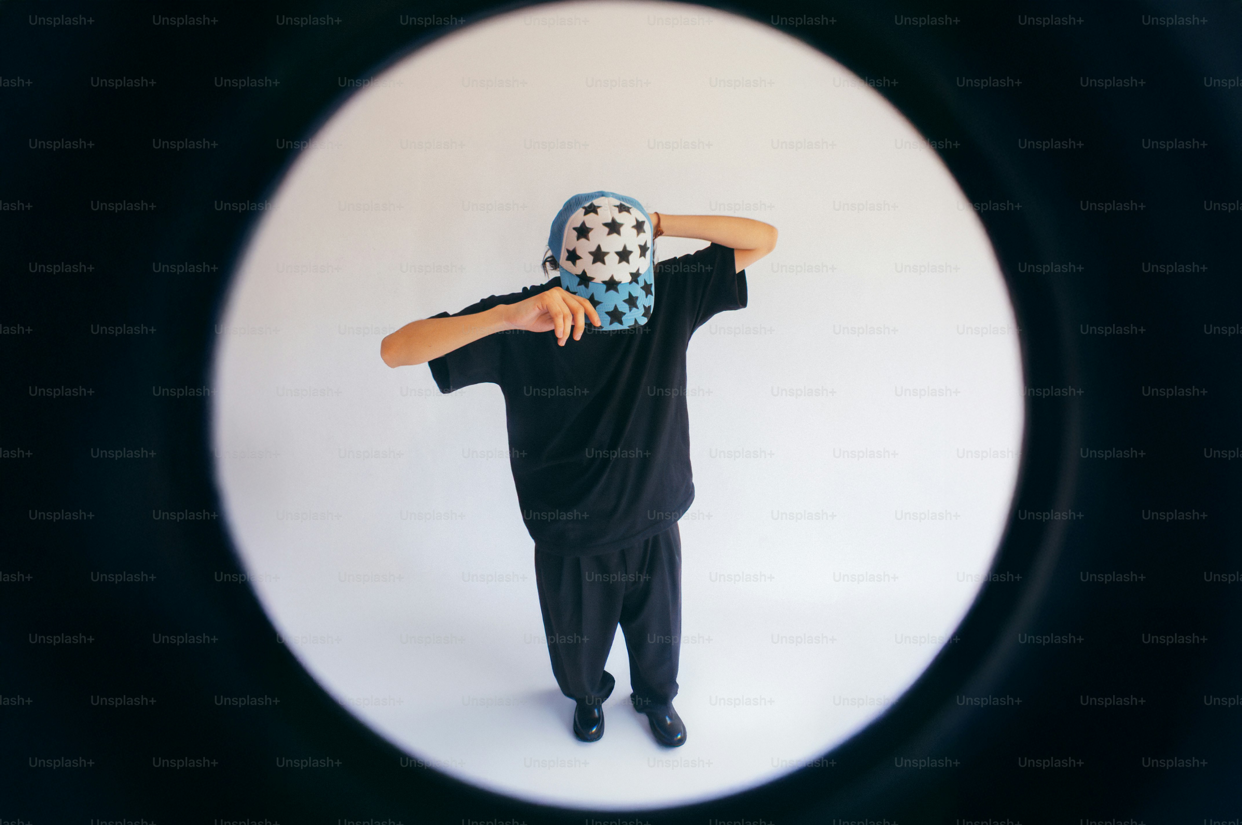 Person with a patterned mask poses in a bright space.