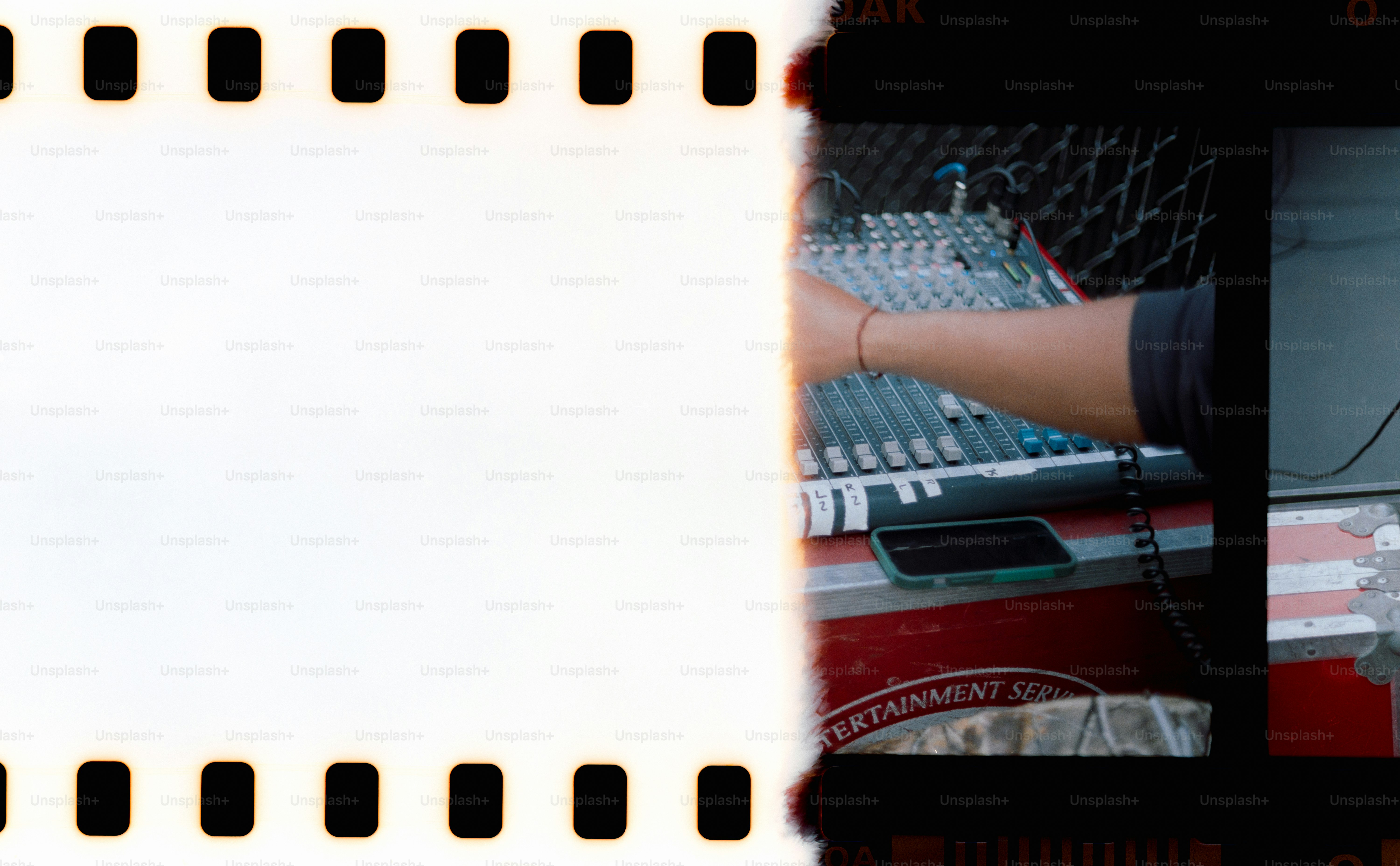 Someone operates an audio mixing board.