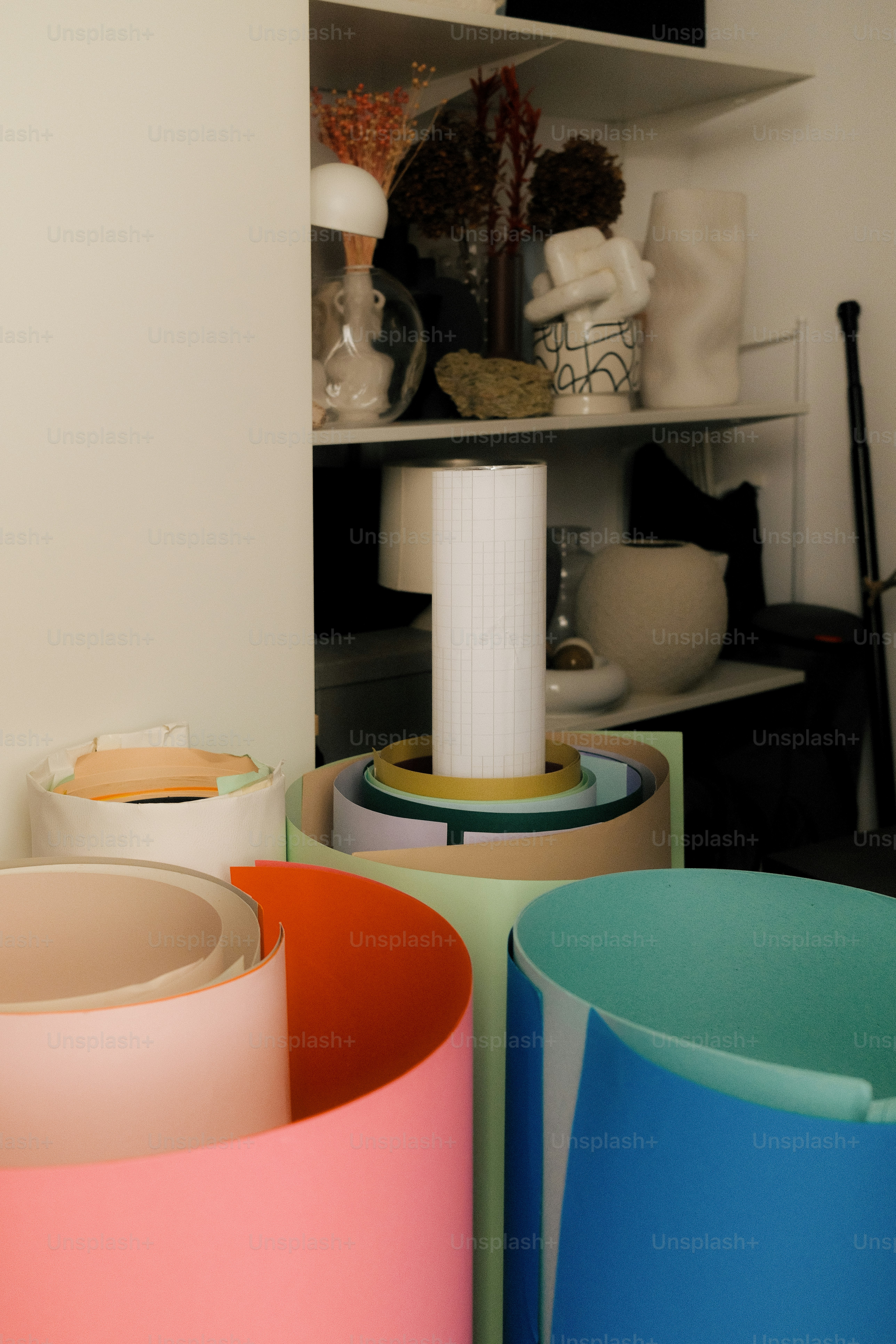 Colorful rolls of paper are displayed in a room.