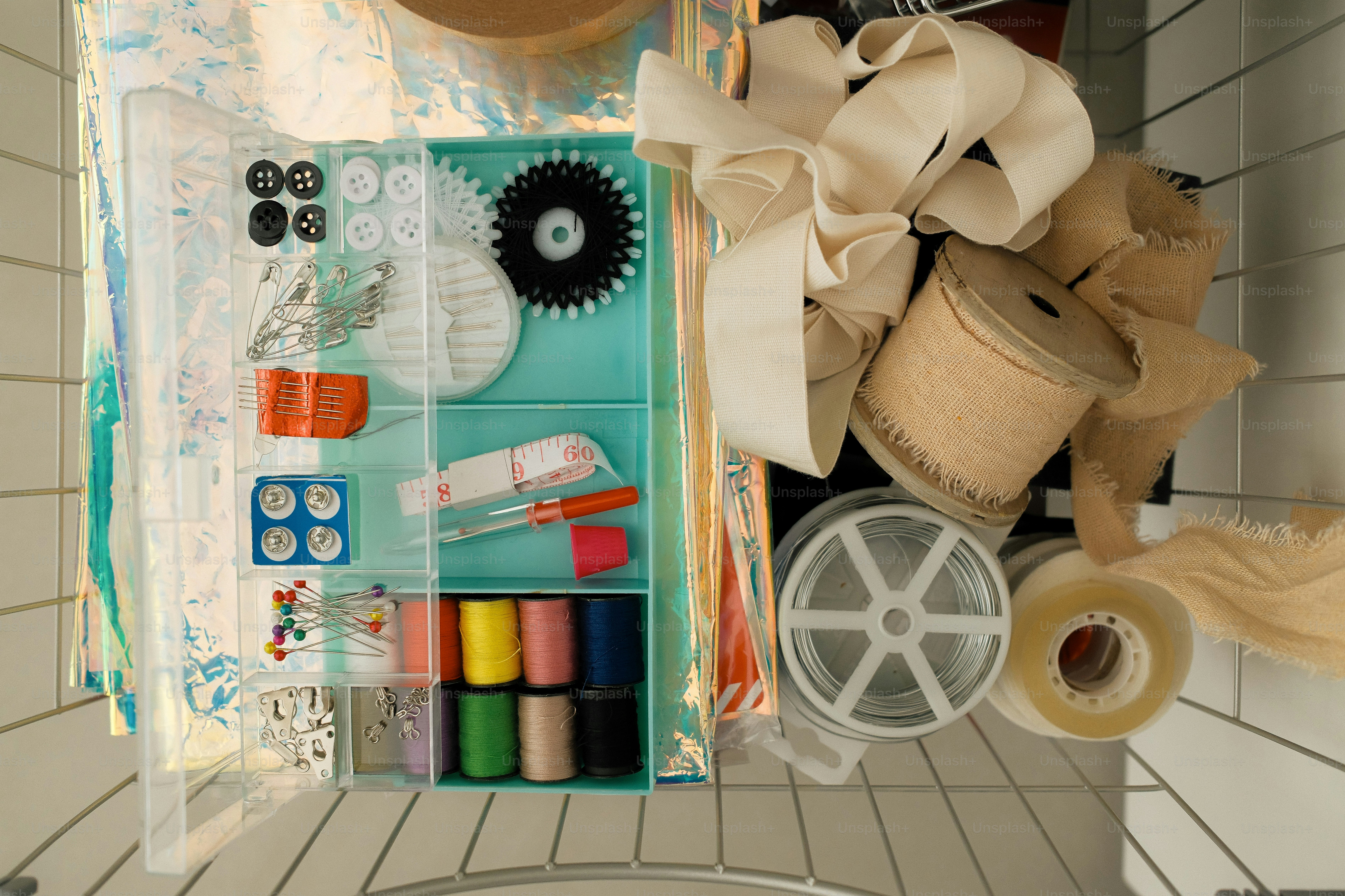 Sewing kit supplies, including spools of thread and fabric.