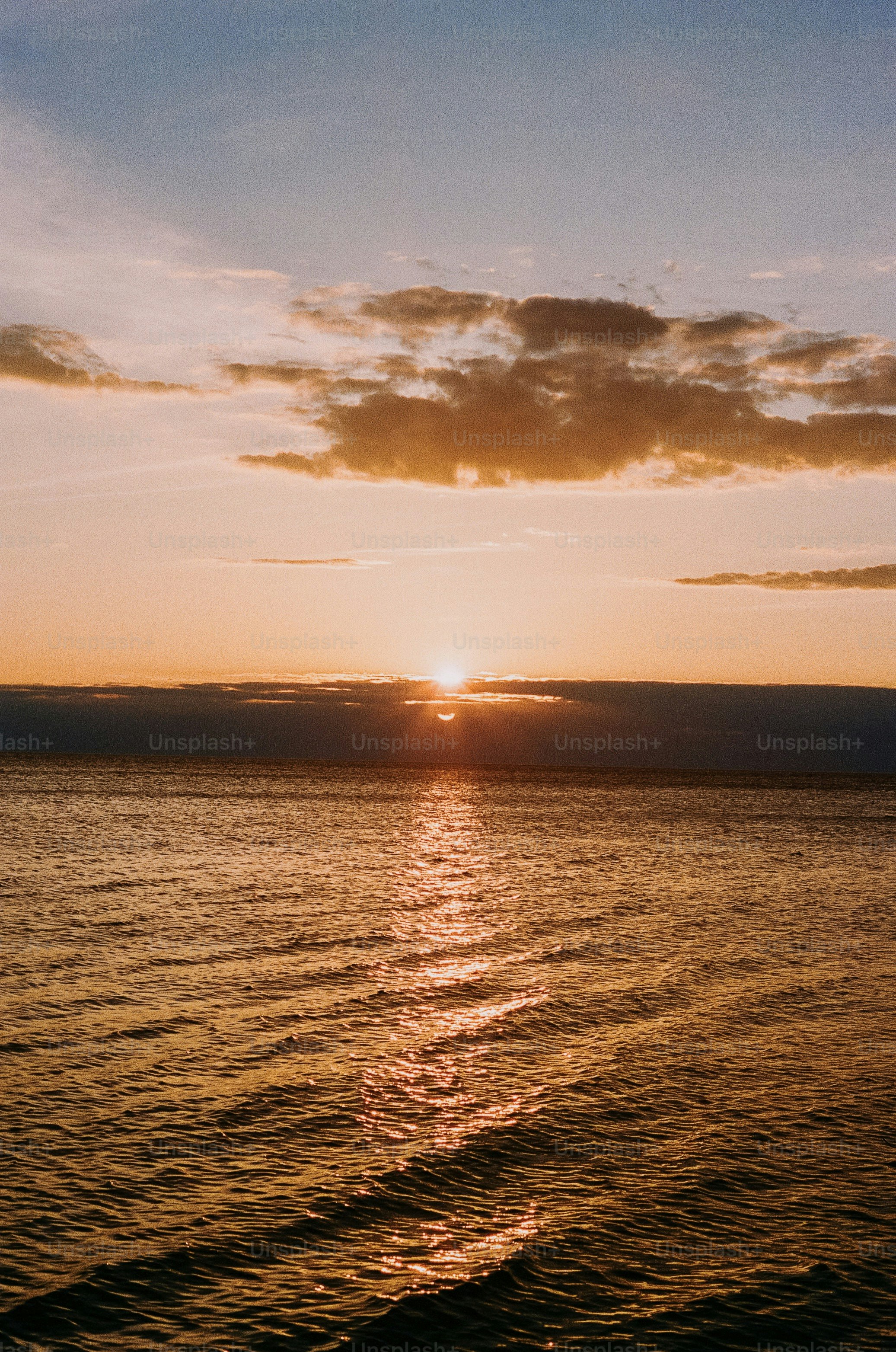 The sun sets over a calm ocean.