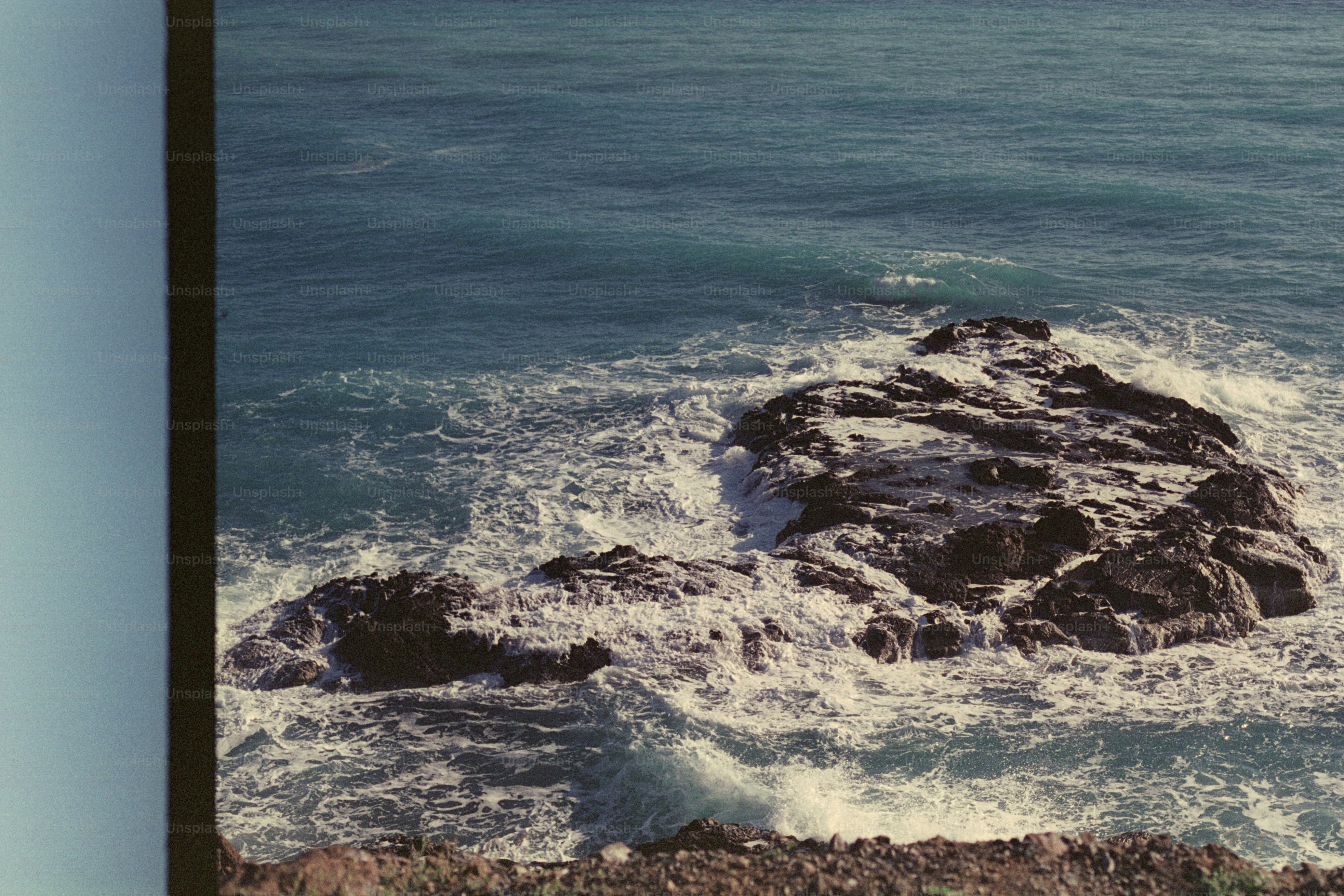 Le onde si infrangono sulle rocce nel vasto oceano.