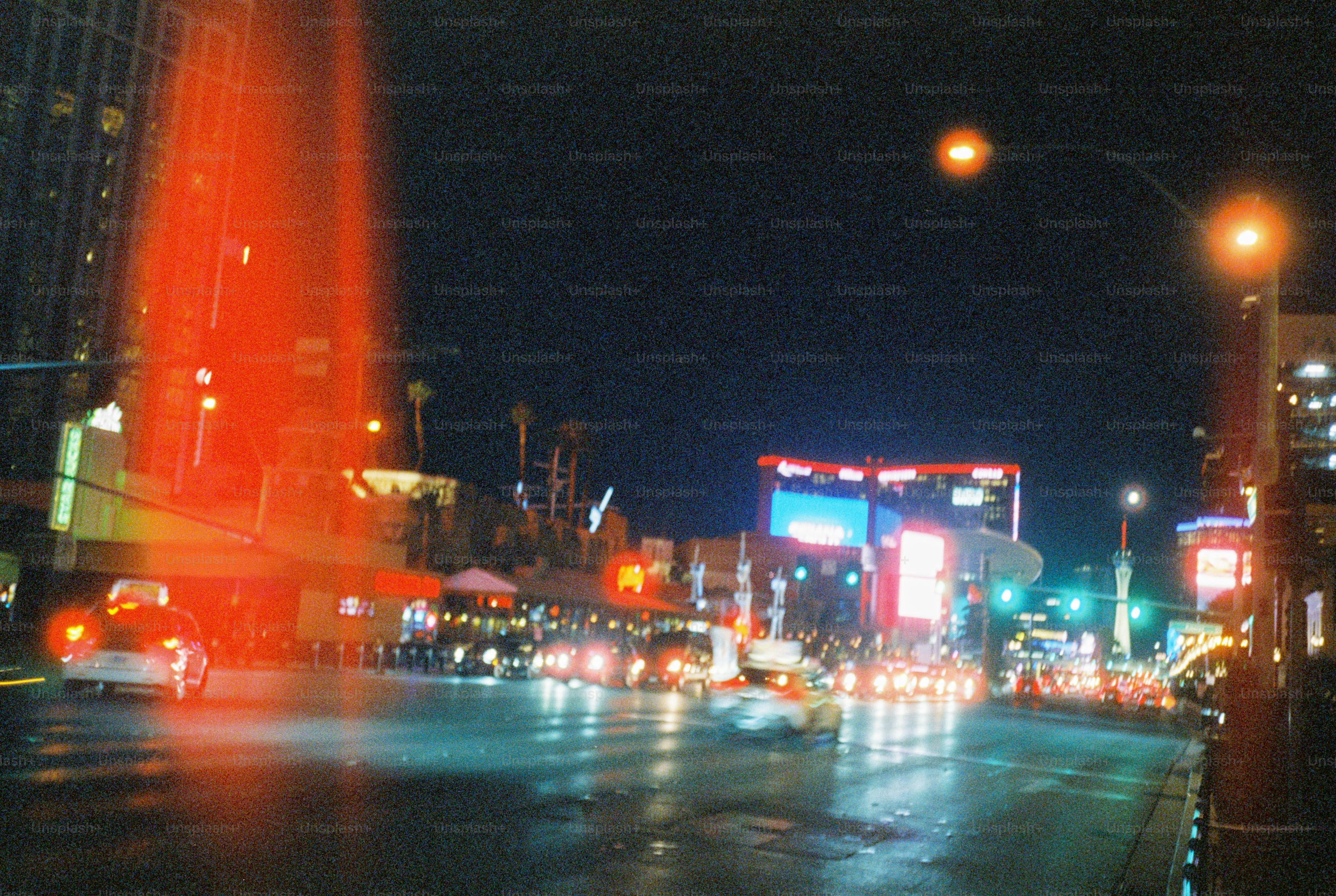 Se muestra la calle nocturna de la ciudad con luces de coches.