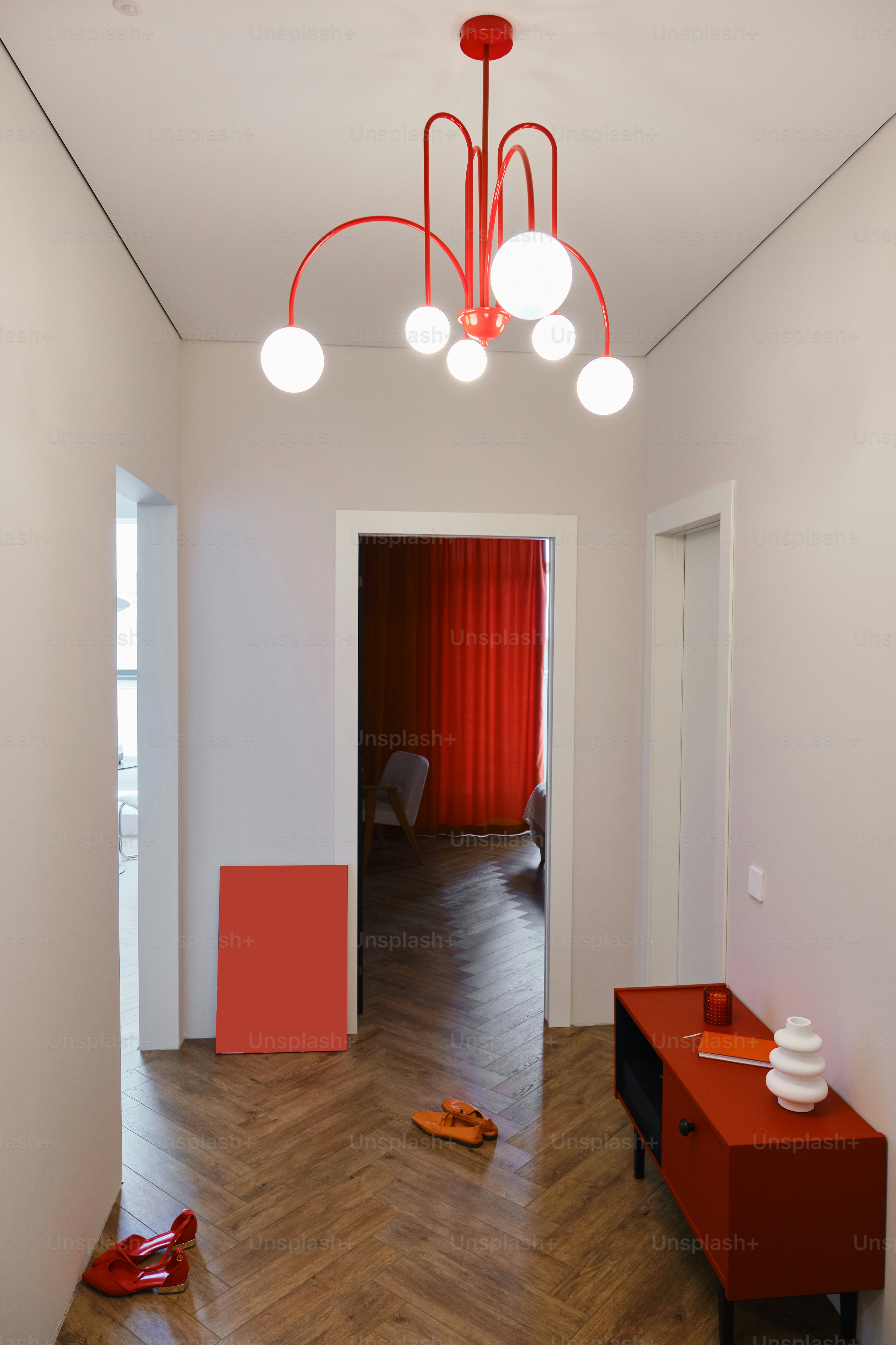 A modern hallway features stylish red accents