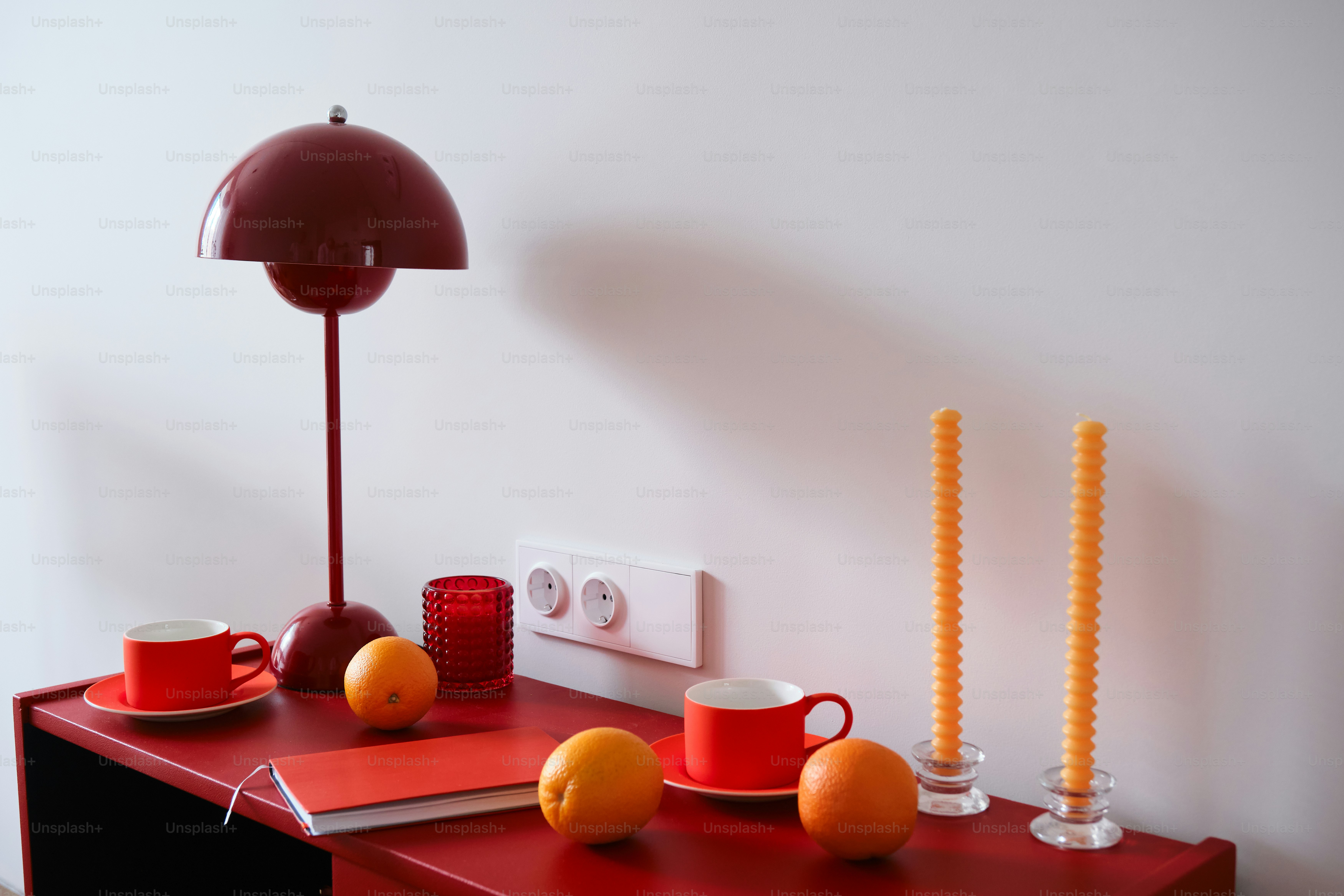 Red decor with oranges and candles is displayed
