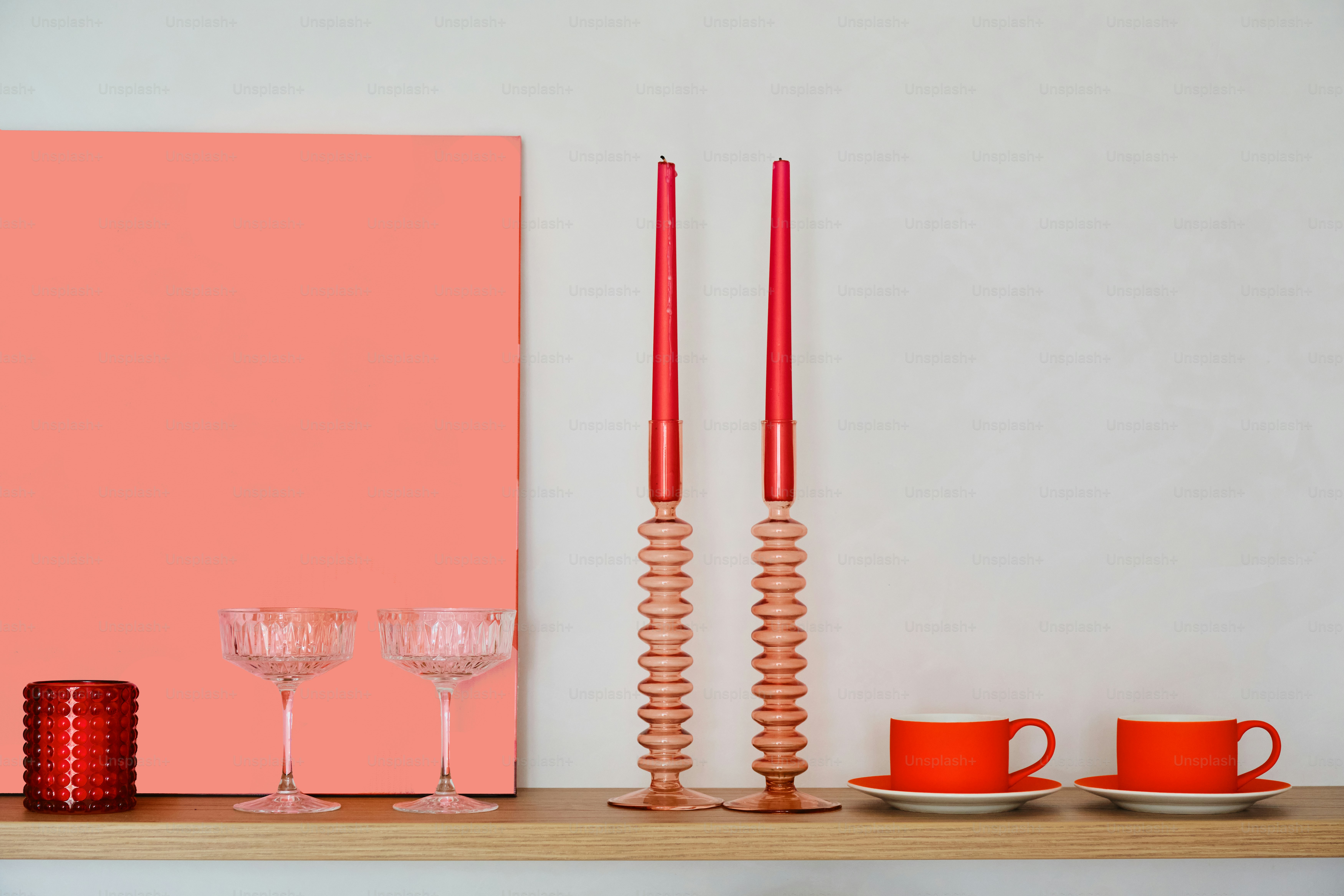 Red and coral decor arranged on a shelf.