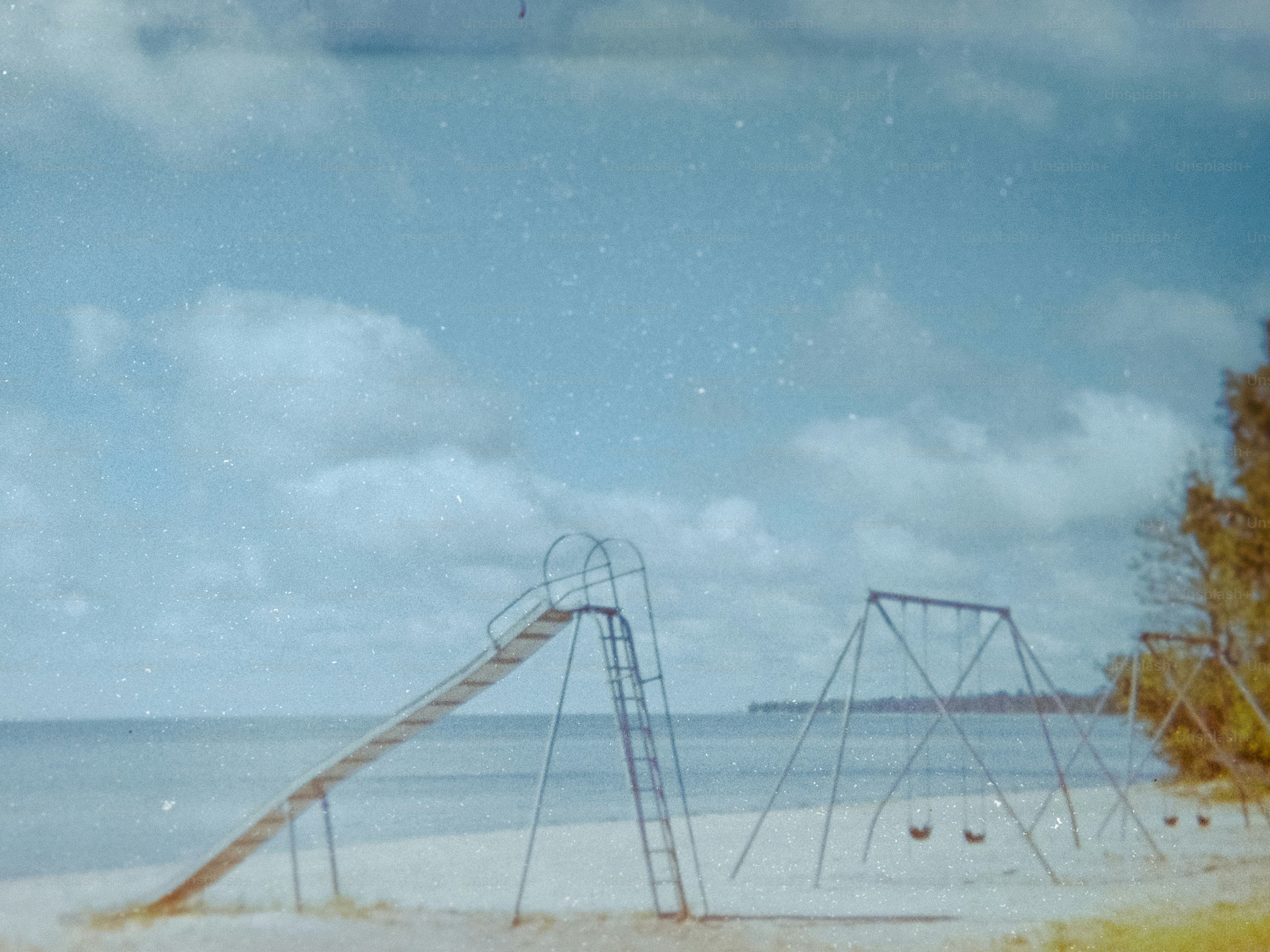 Playground equipment sits on a sandy beach