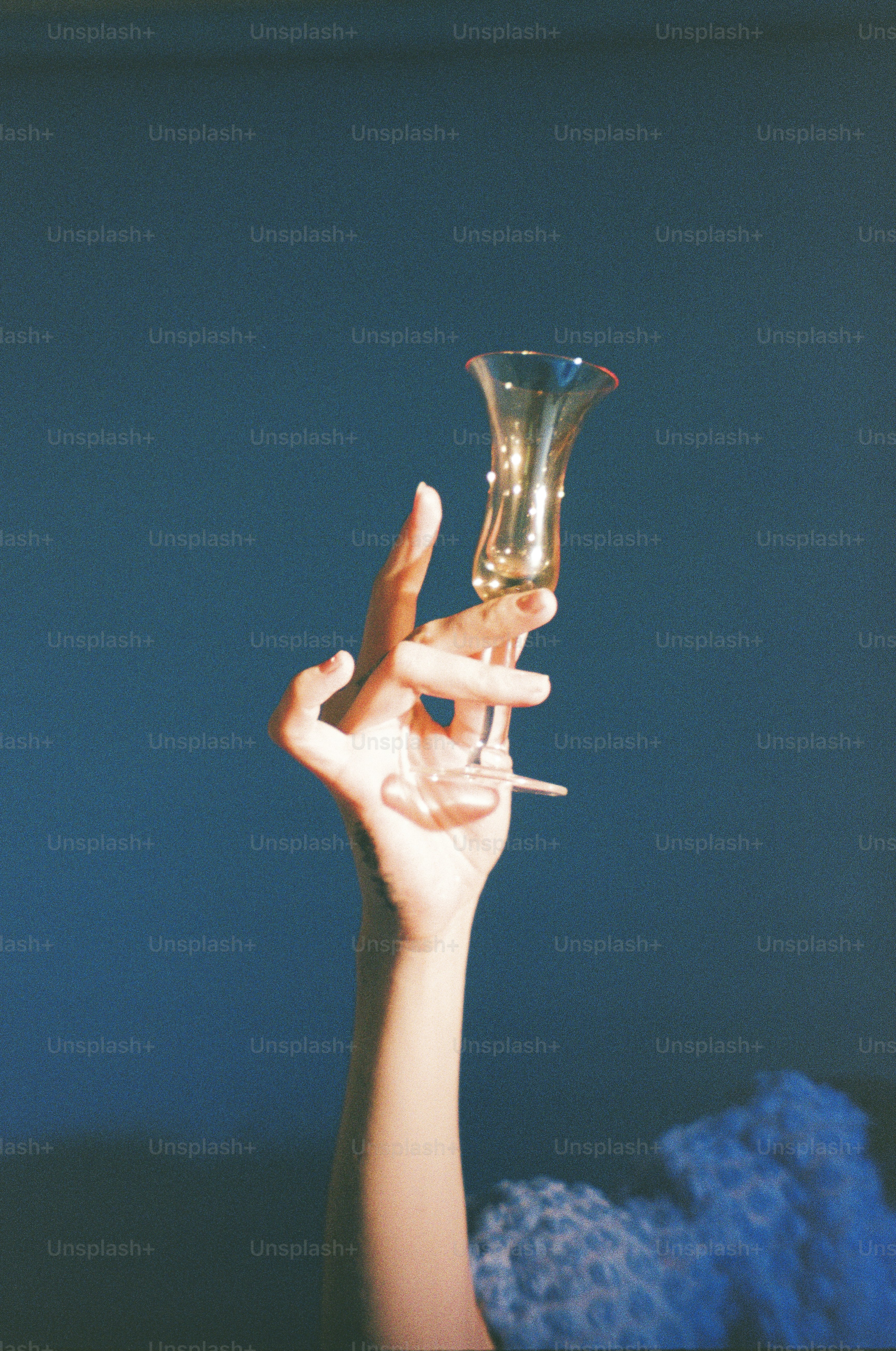 A hand holds up a delicate glass.