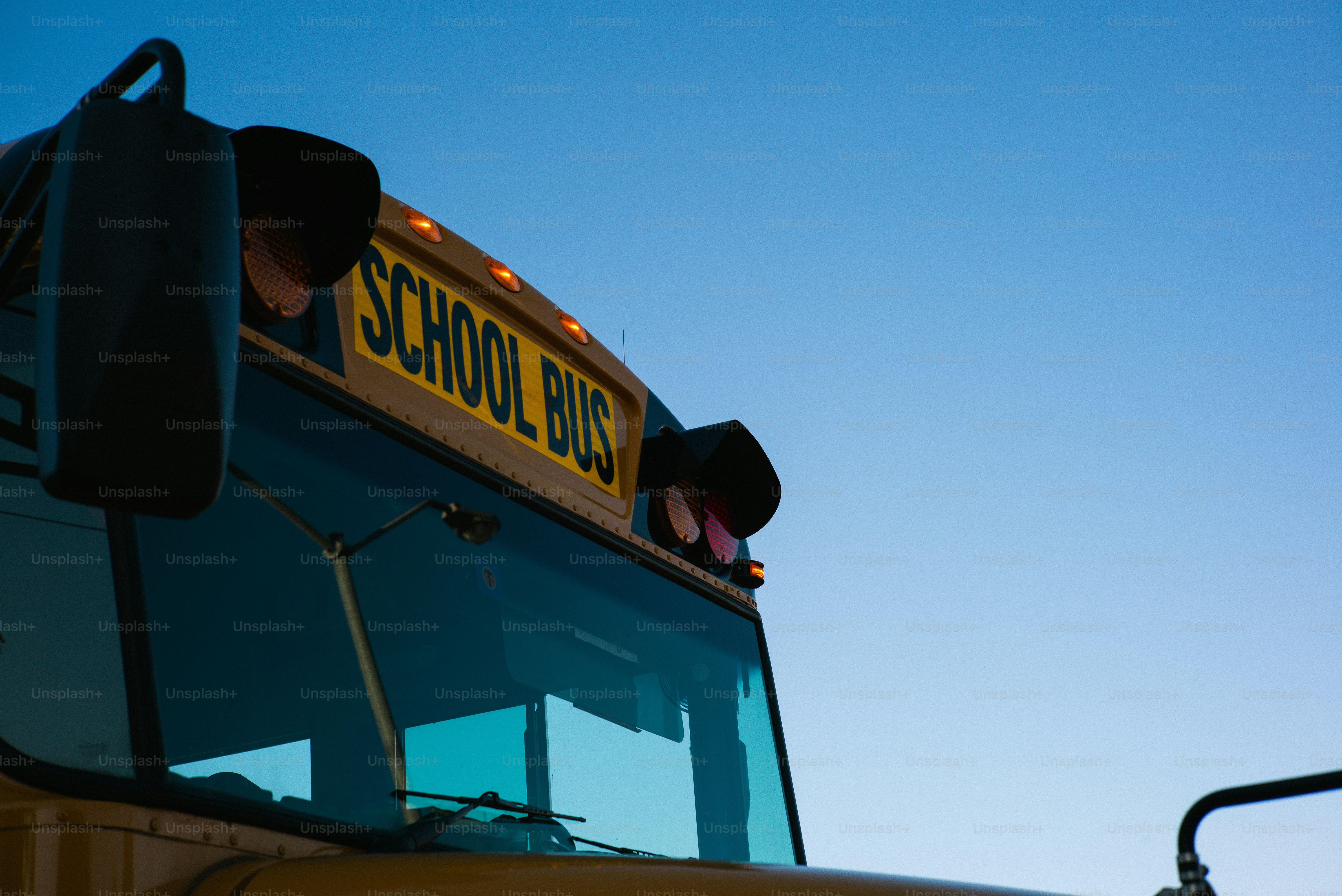 A school bus is against a bright, blue sky.