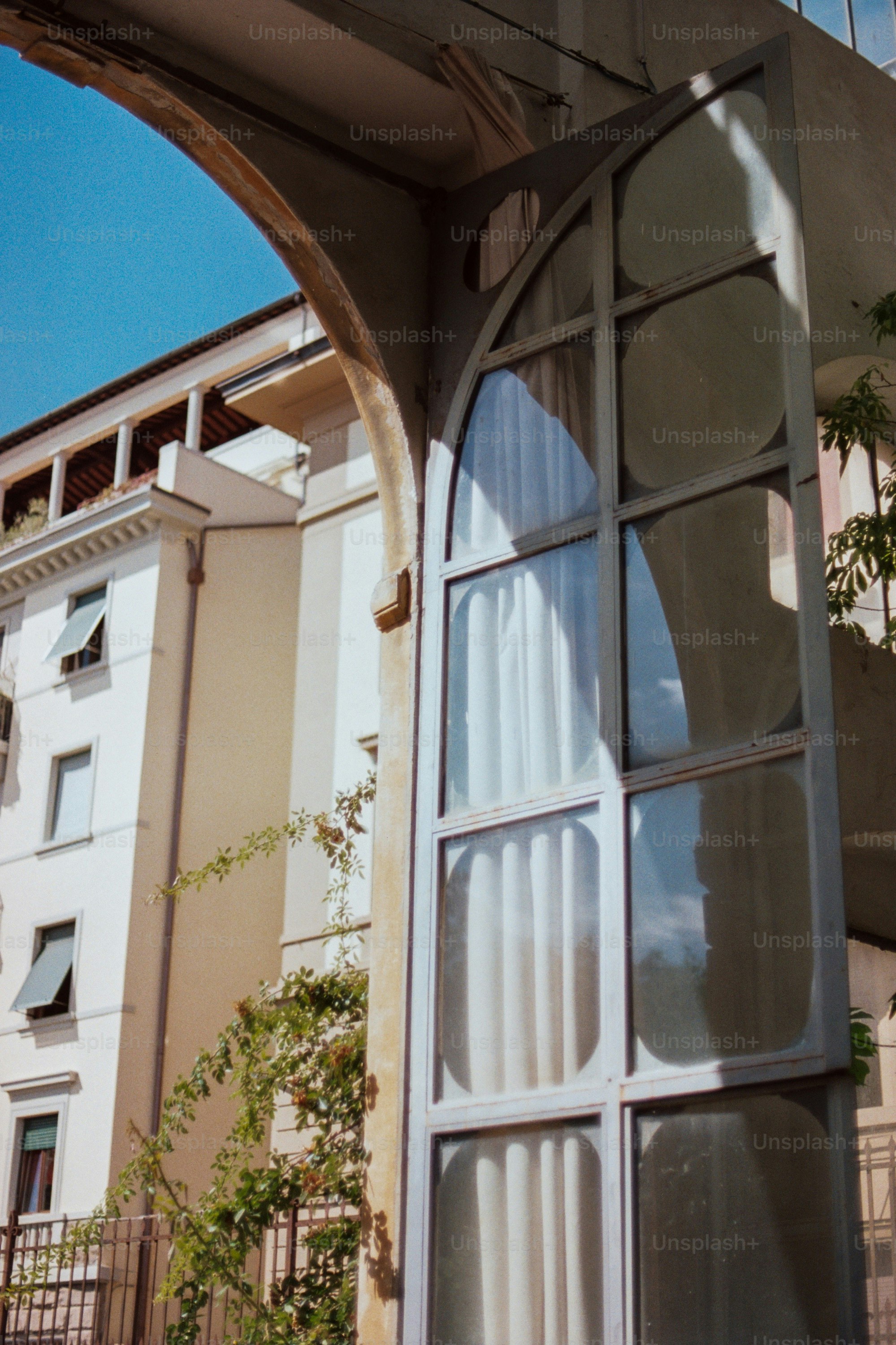 An arched window and building exterior are shown