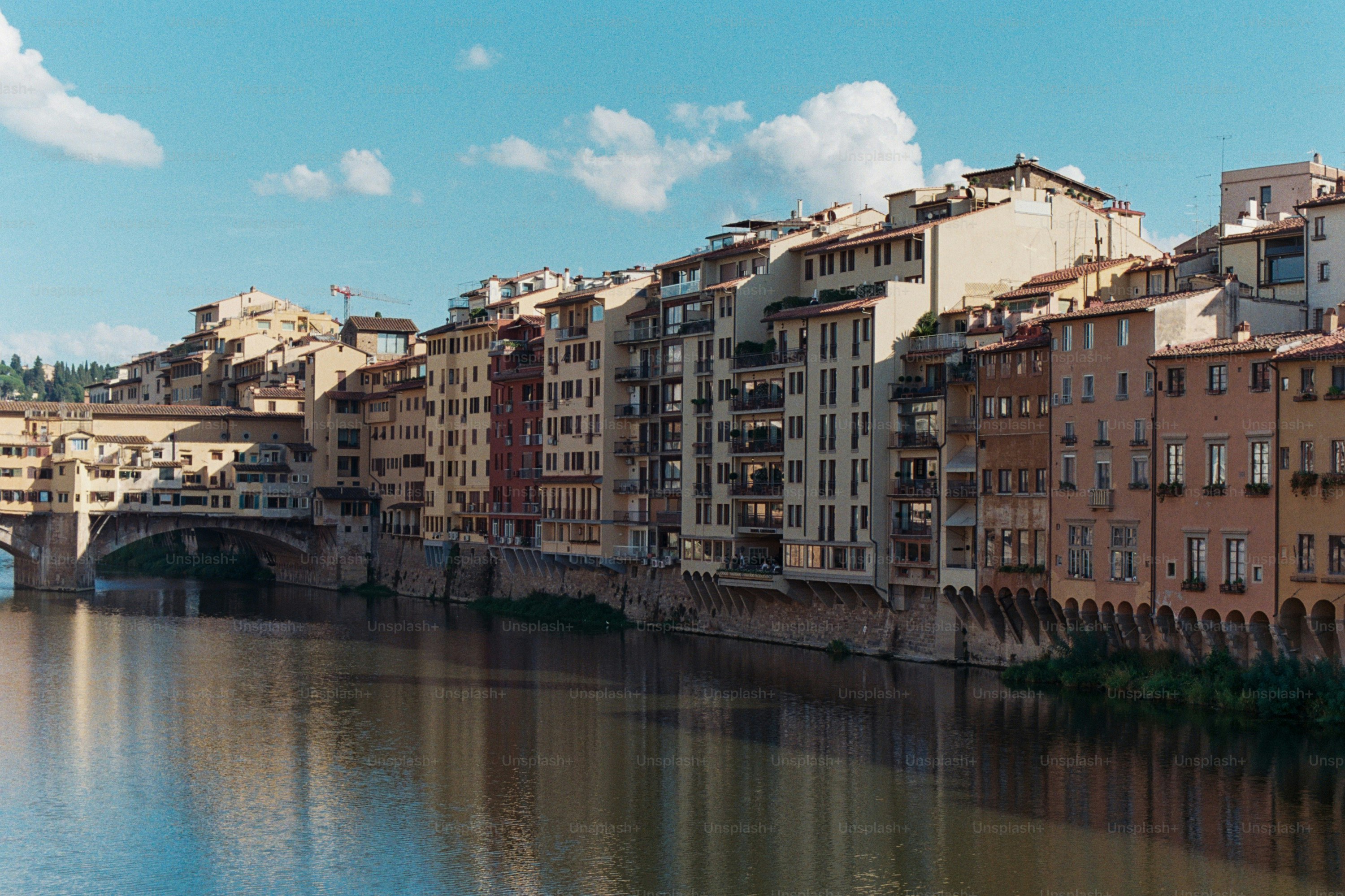 Buildings line a river under a blue sky