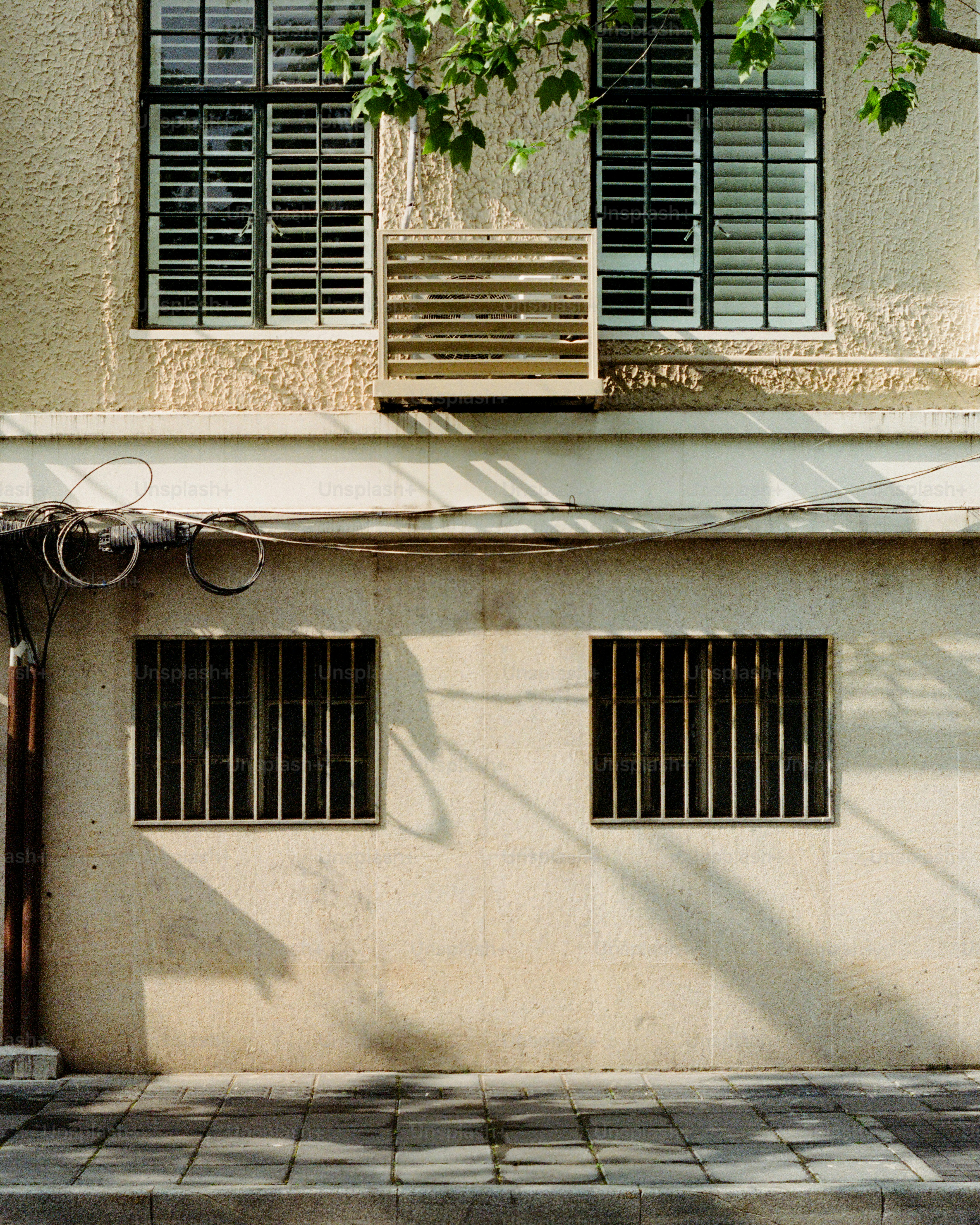 A building exterior with windows and an air conditioner.