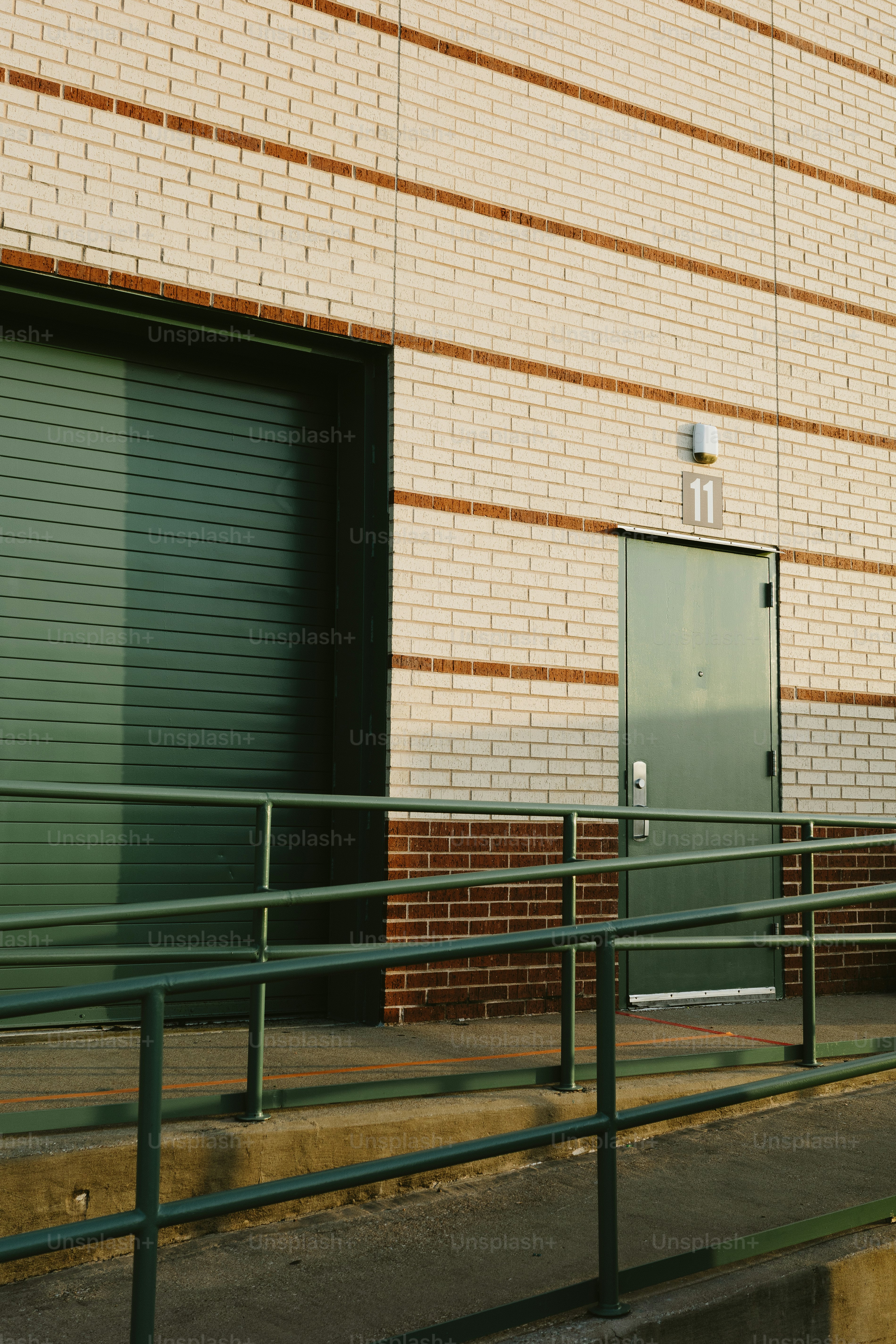 Green door and wall of brick on an industrial building