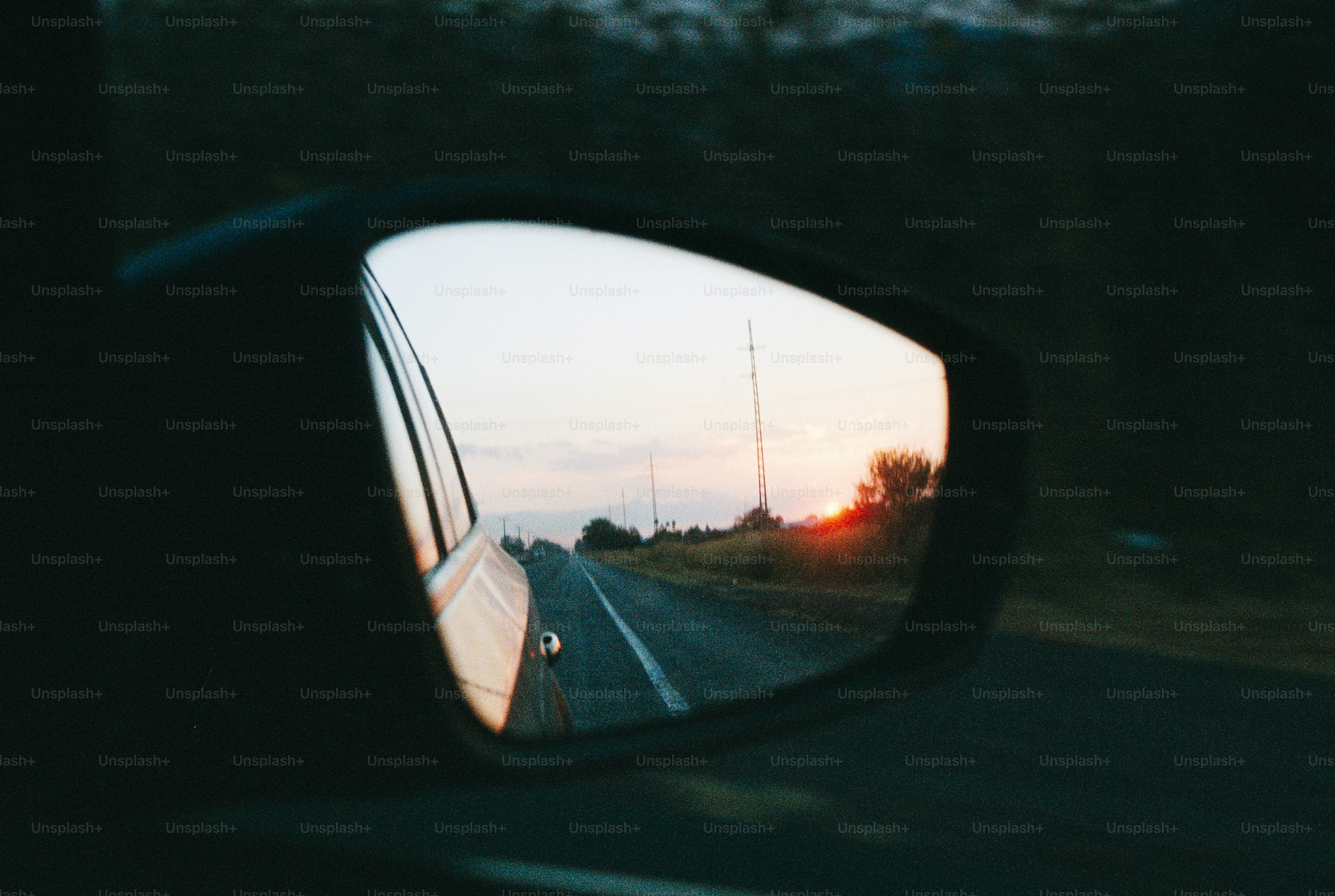 Sunset reflected in a car's side mirror.