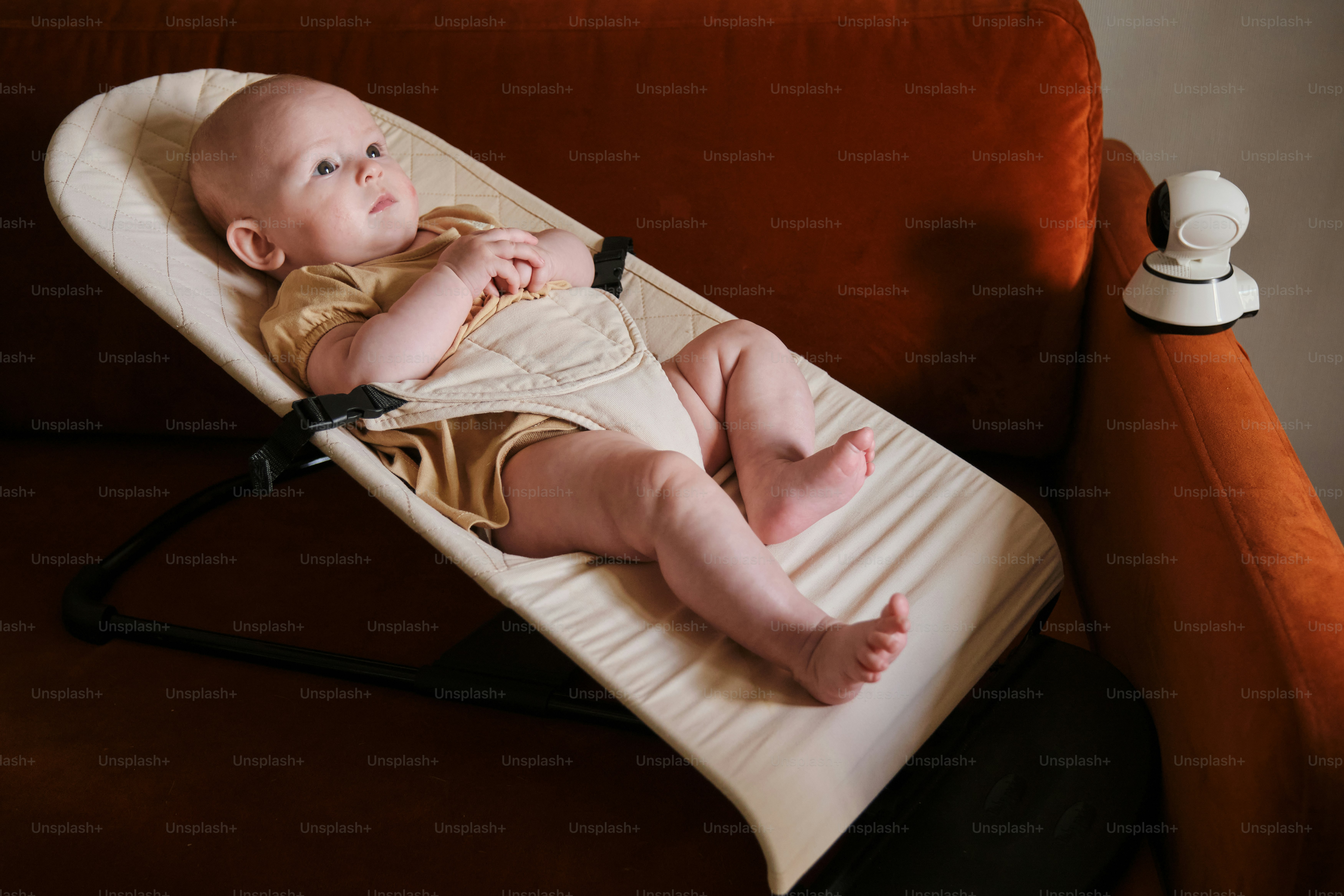 Bébé se détend dans un transat près d’une caméra.