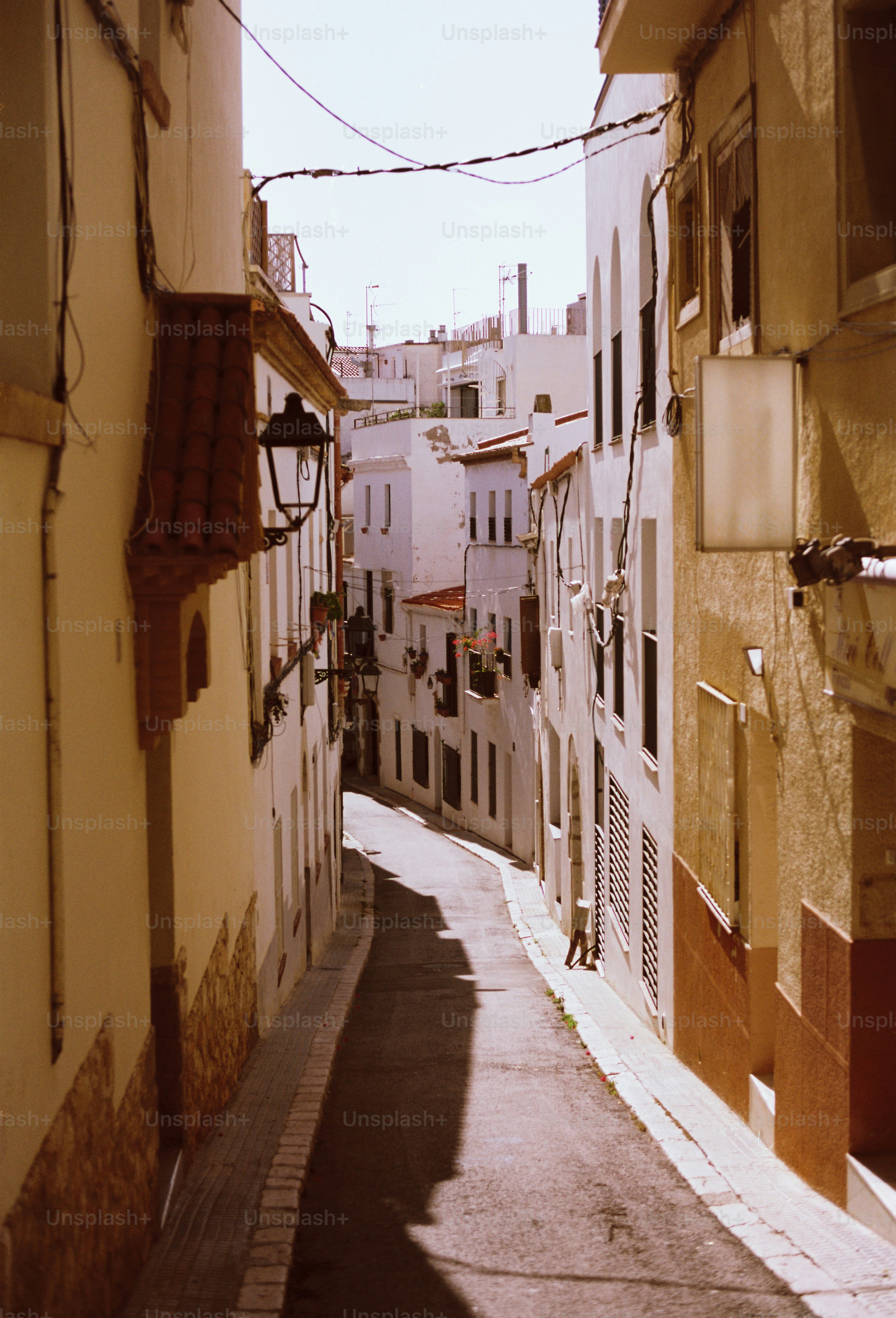 A narrow, sunlit street in a european town.