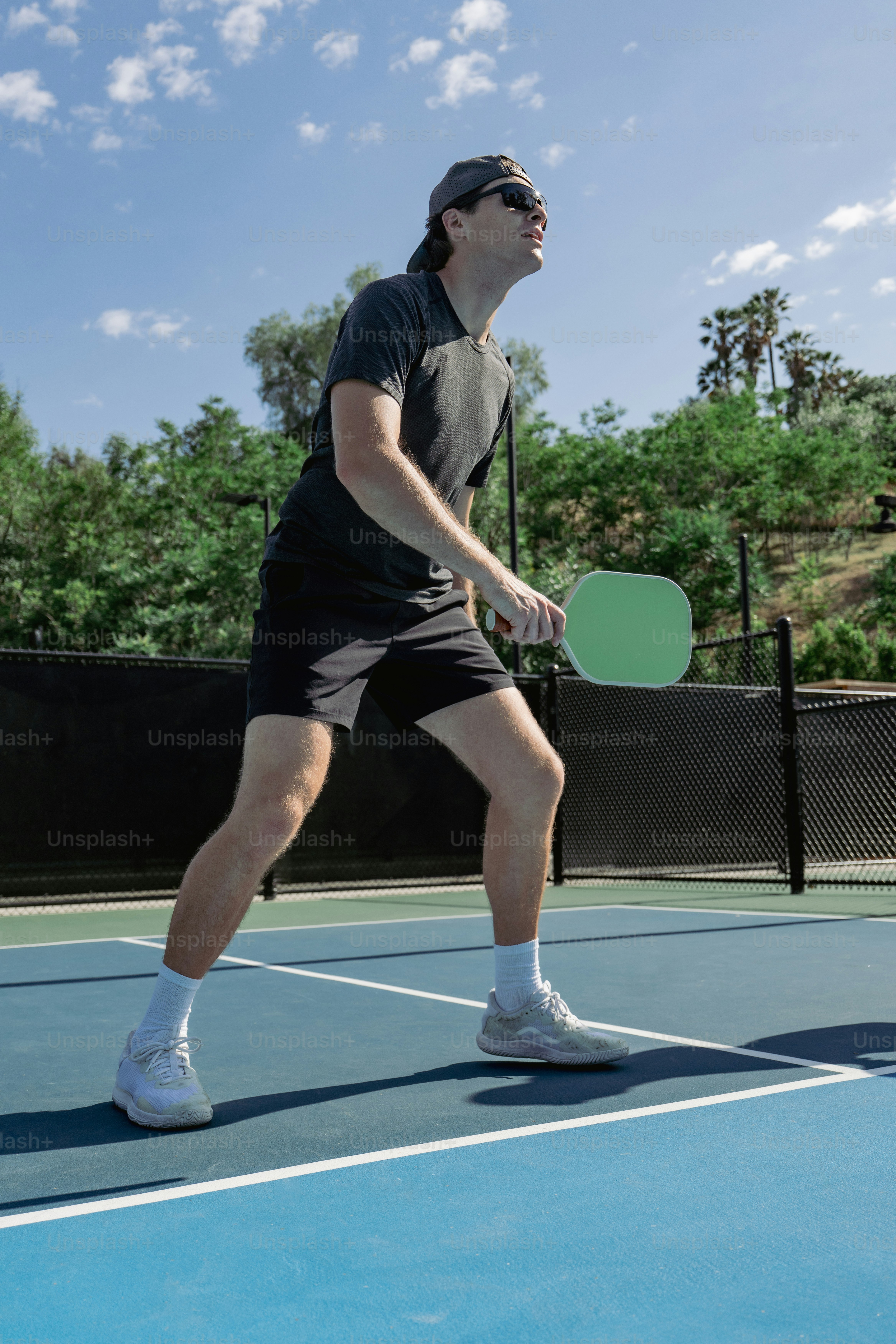 Un homme joue au pickleball par une journée ensoleillée.