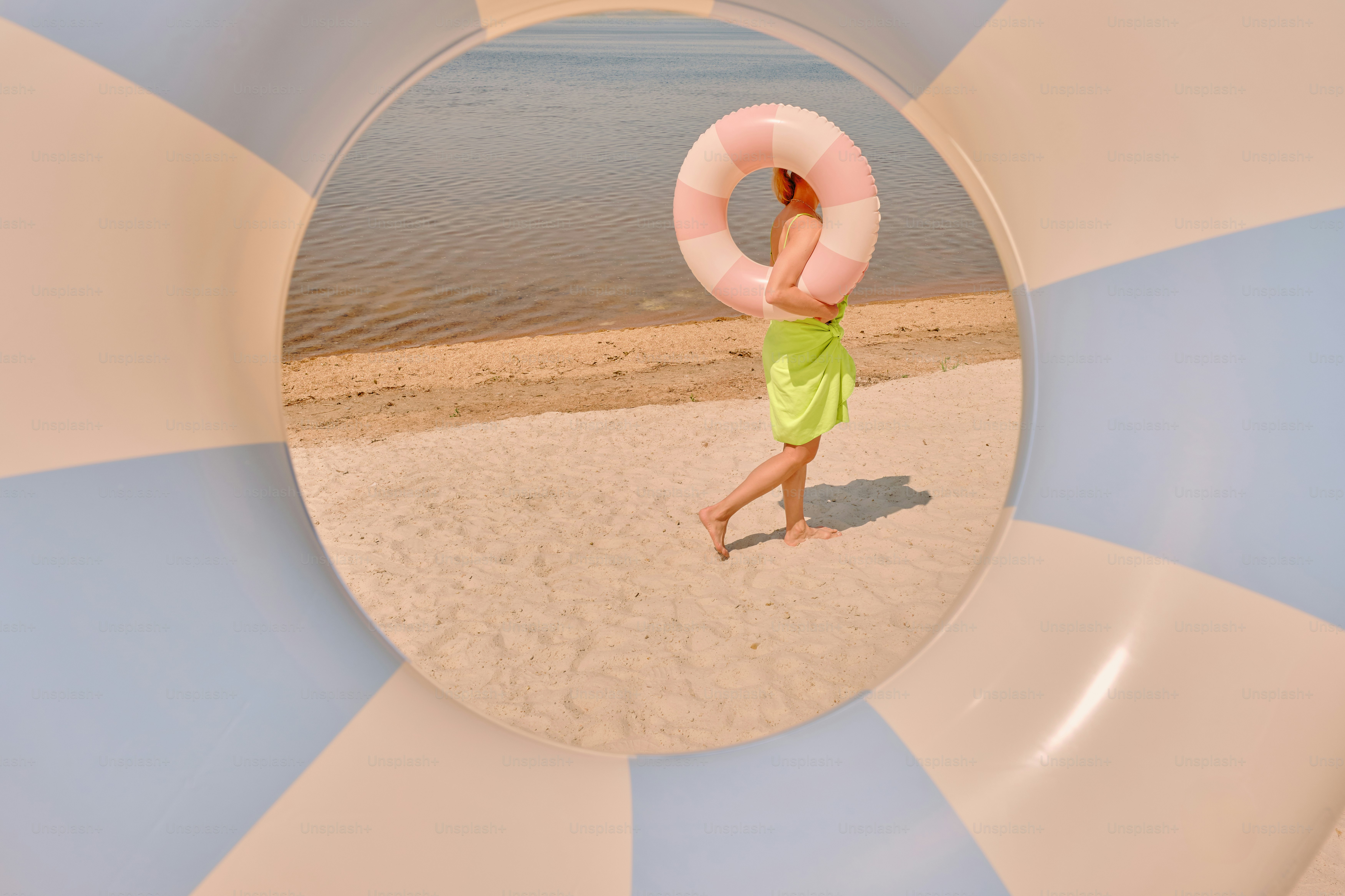 A woman walks on beach holding a life ring.